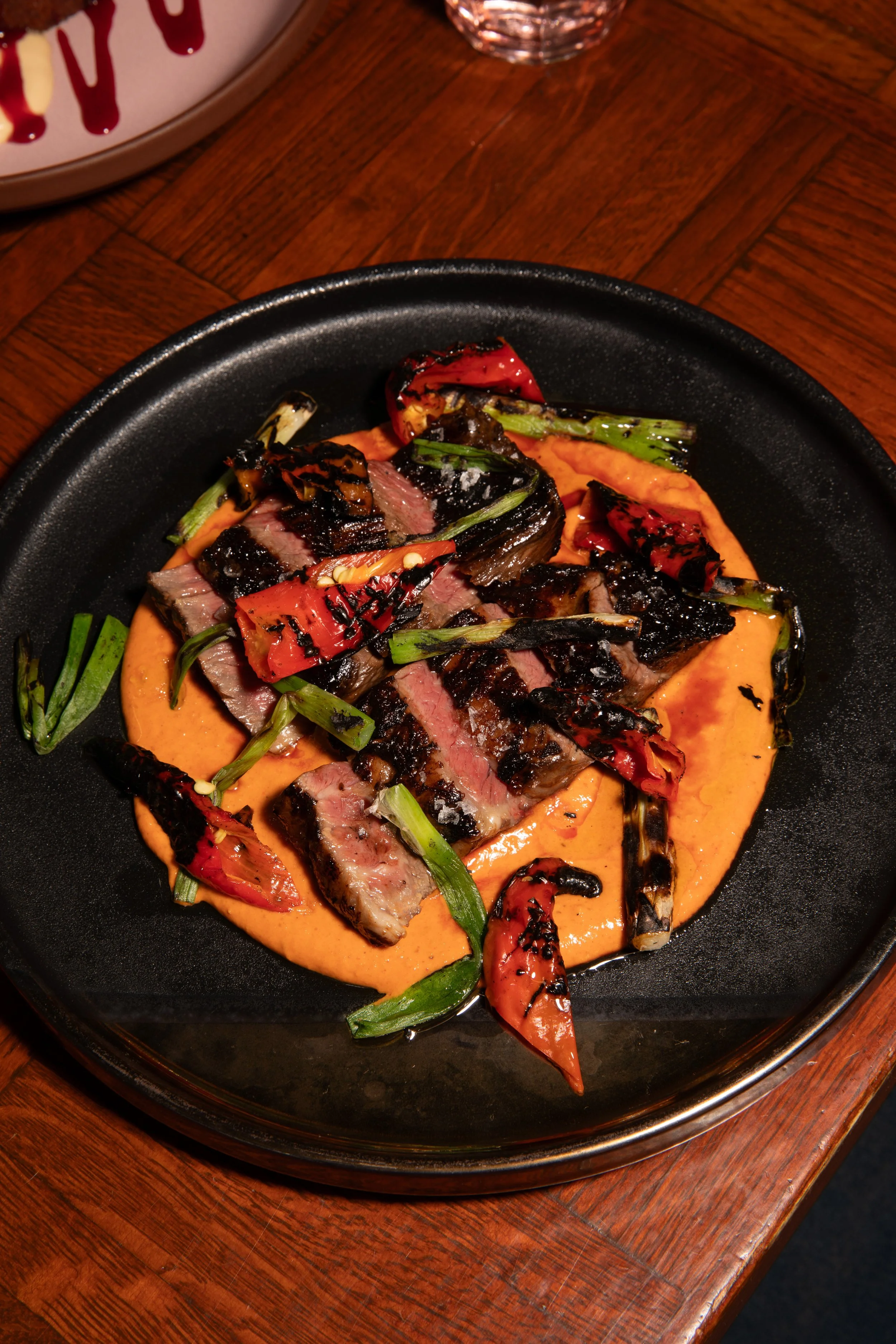 skirt steak with romesco, grilled peppers and onion