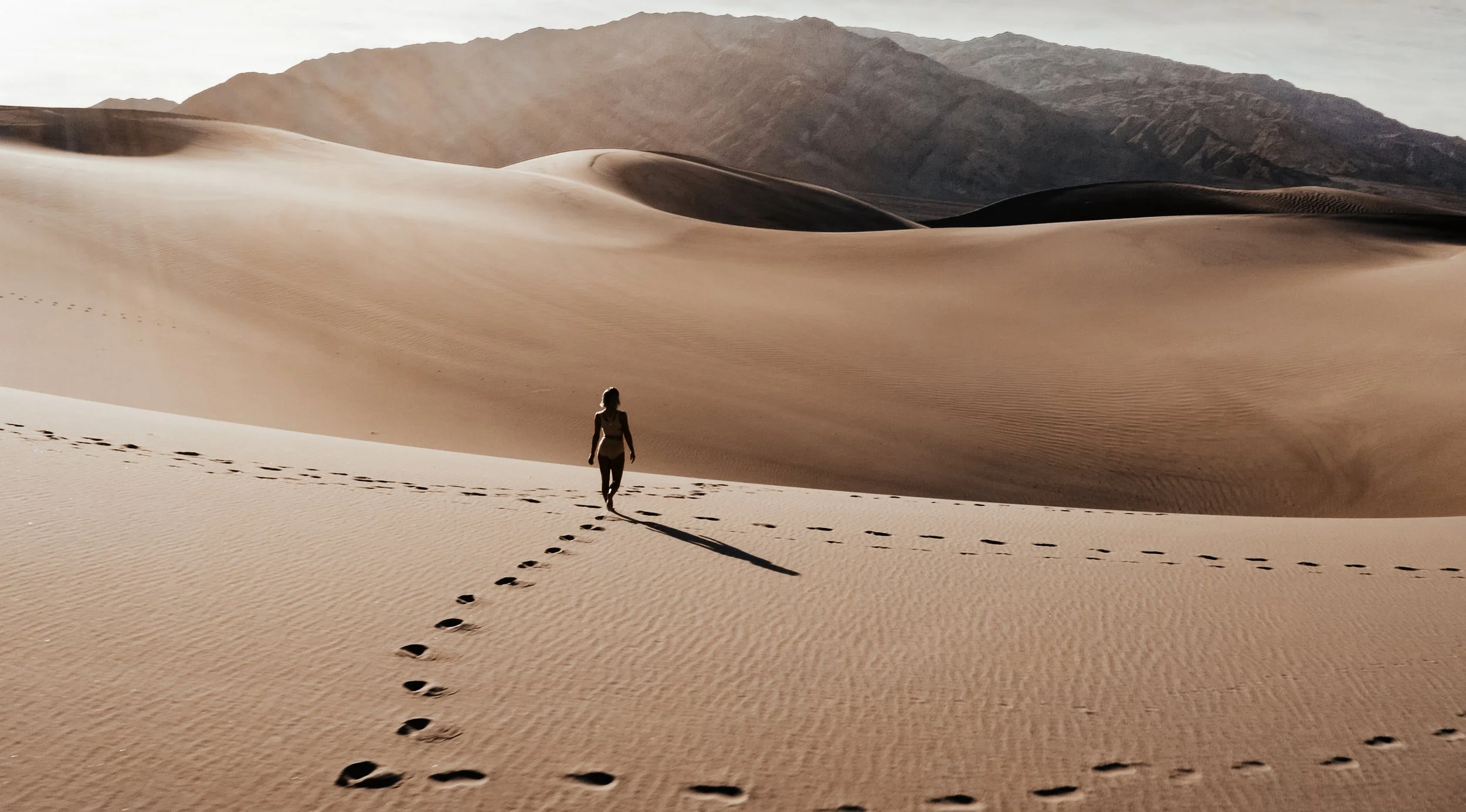 Julianne Hough for KINRGY walking alone across desert sand dunes.