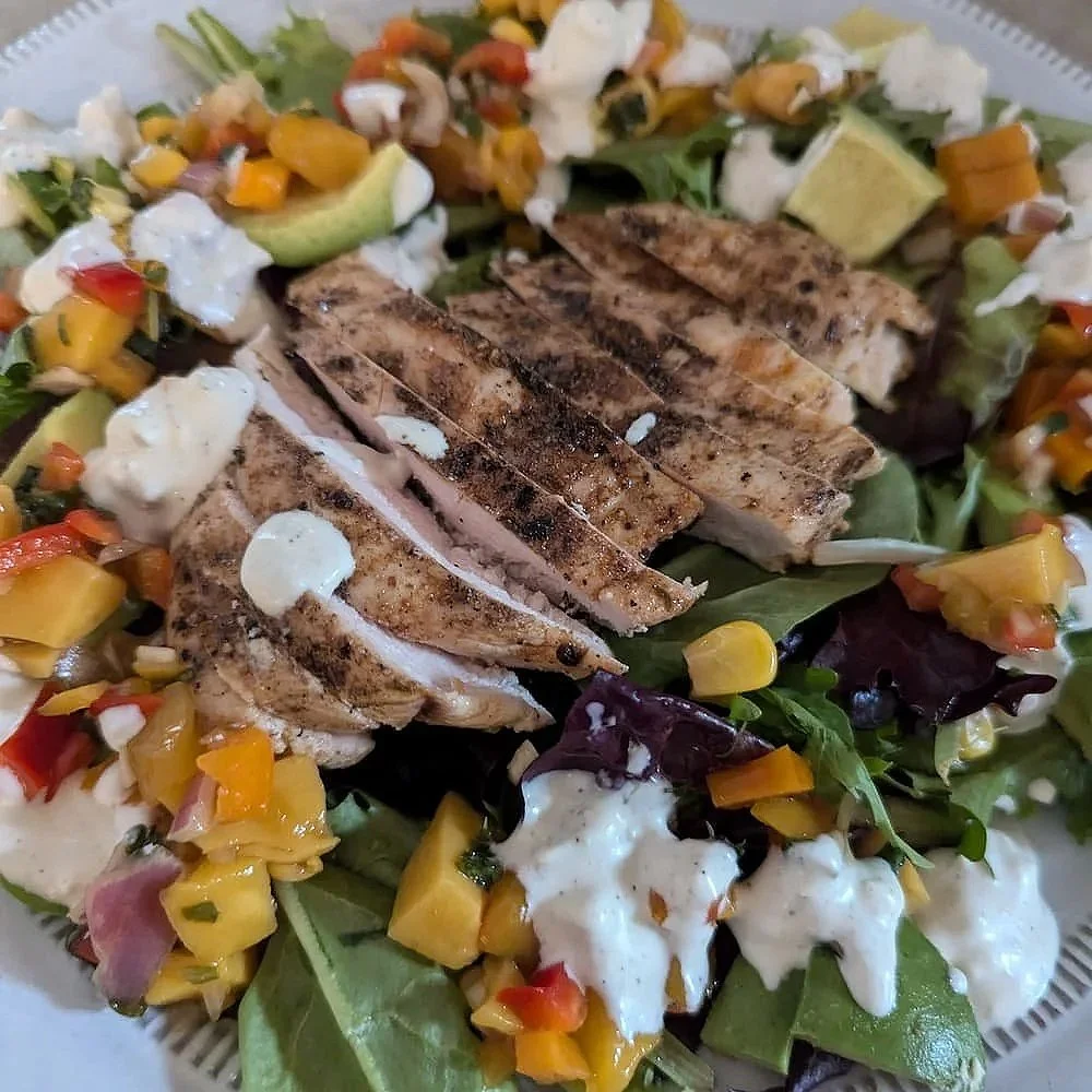 A fresh salad topped with grilled chicken breast seasoned with Hogtown Taco Seasoning, a sweet mango salsa, and creamy blue cheese dressing.