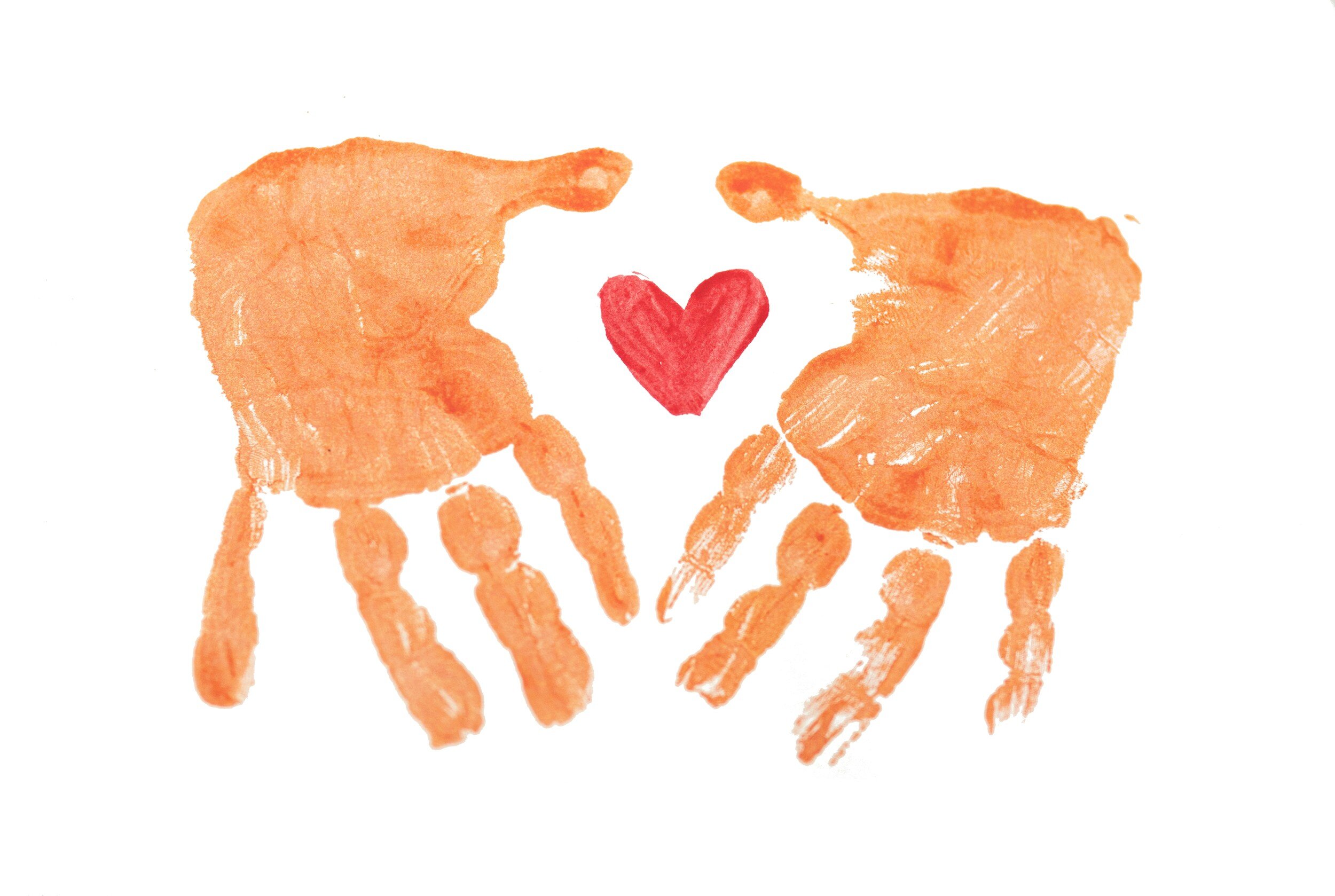 Two orange handprints with a red heart between them on a white background.