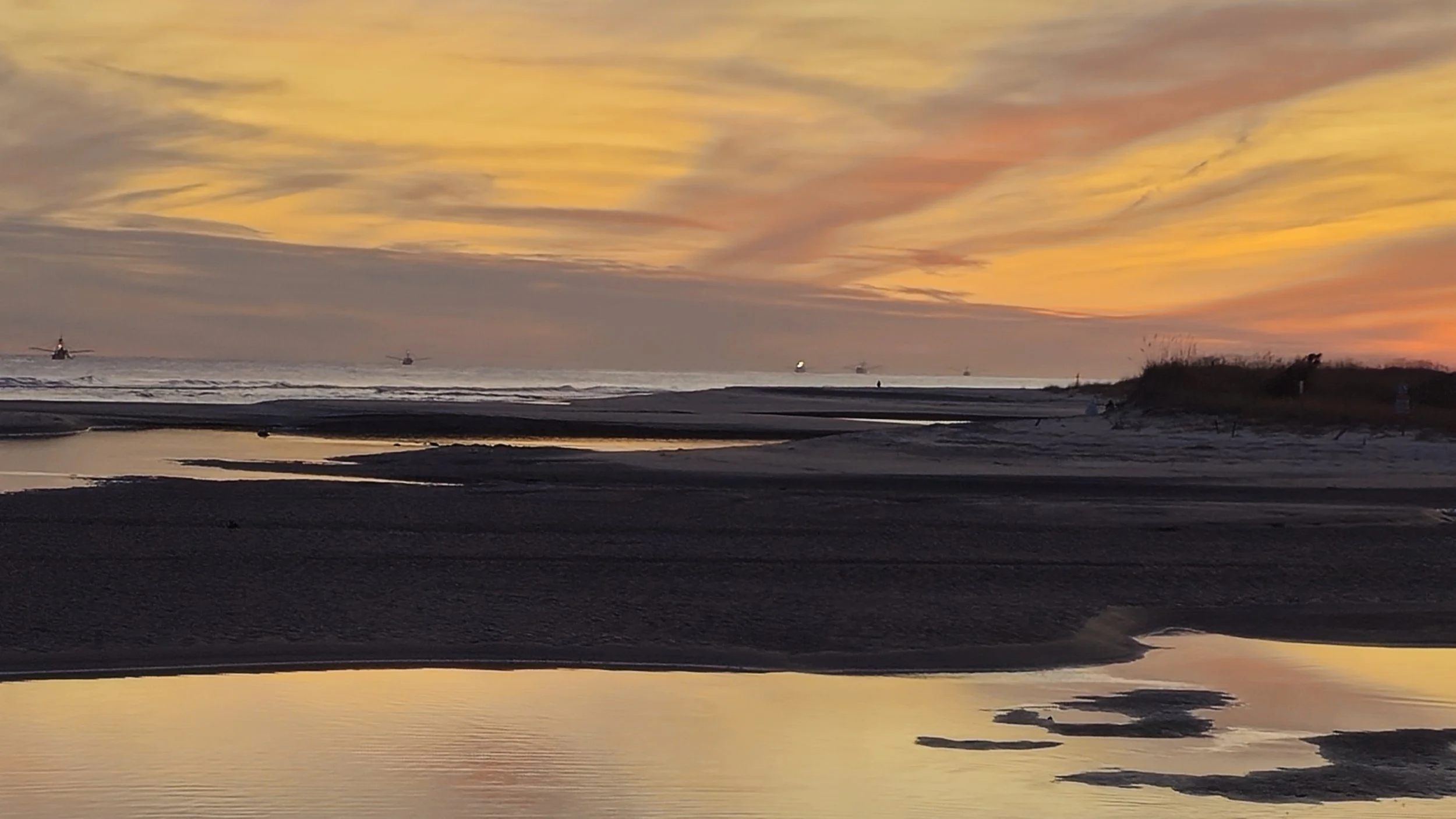 Shrimp boats offshore at sunset, seen from the beach at Ocean Creek Resort, North Myrtle Beach