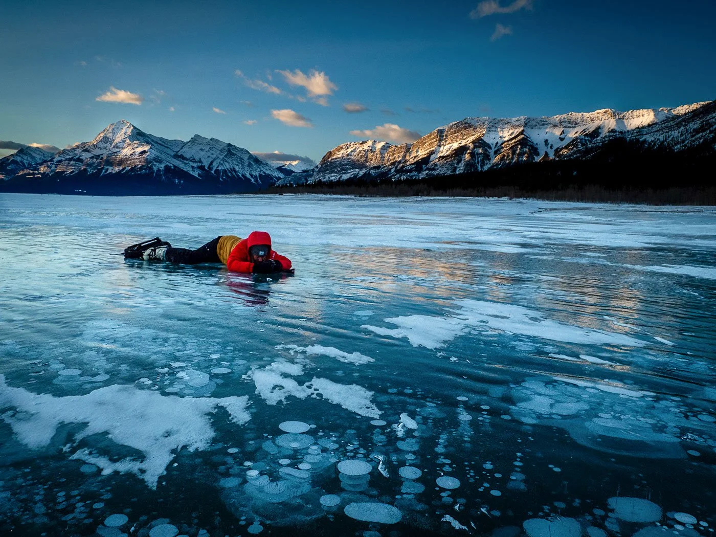 Nature Photographer looking at ice bubbles Abraham Lake