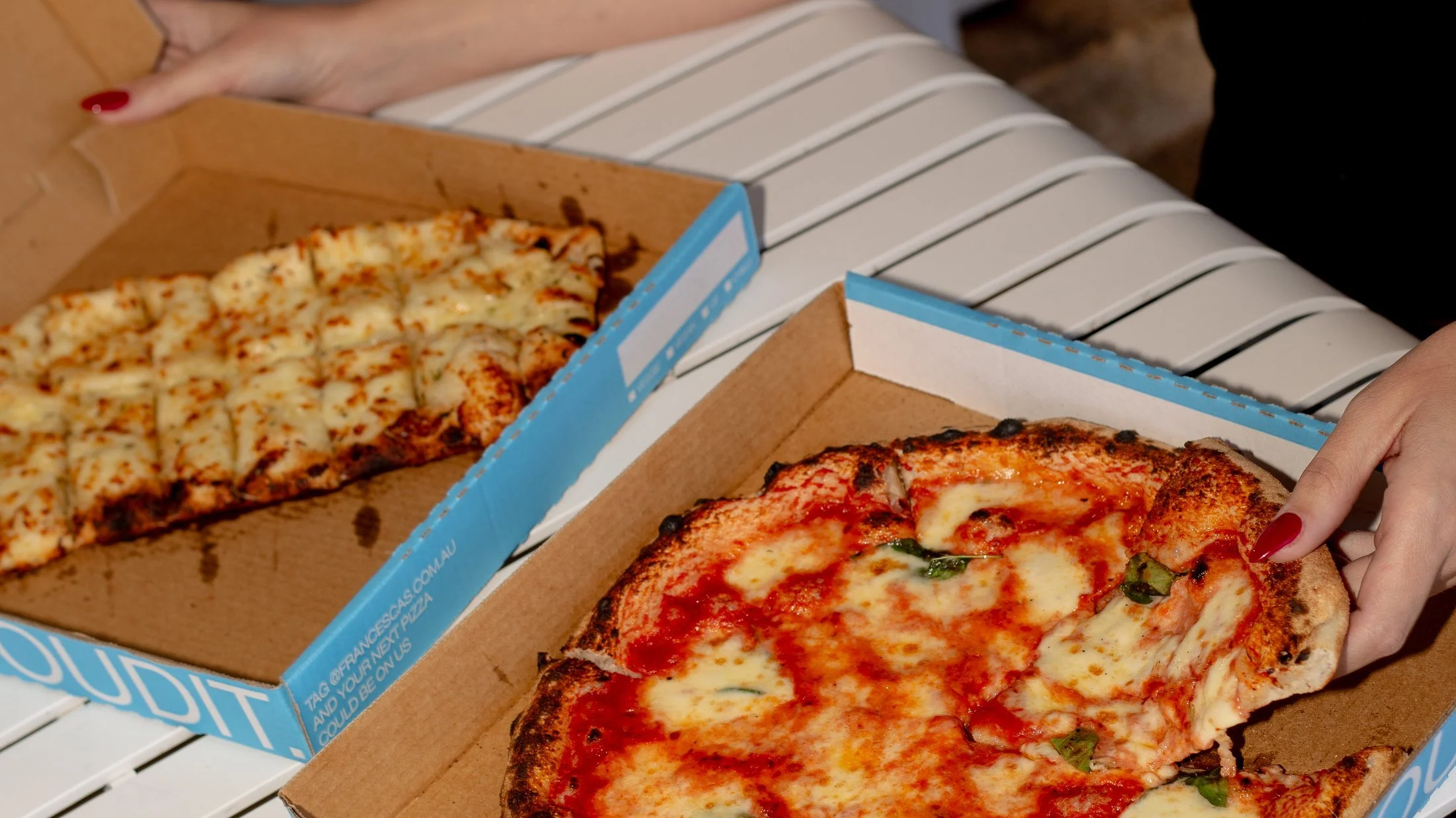 Wood fired pizzas cut and open in Francesca's boxes, ready to serve