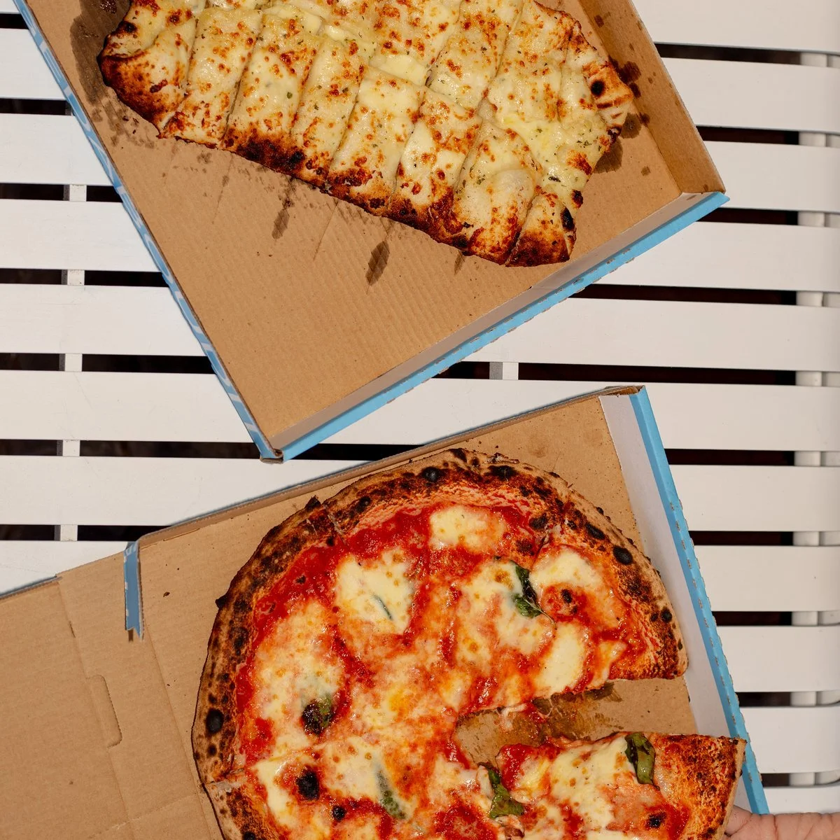 Wood fired pizzas cut and open in Francesca's boxes at a catering job