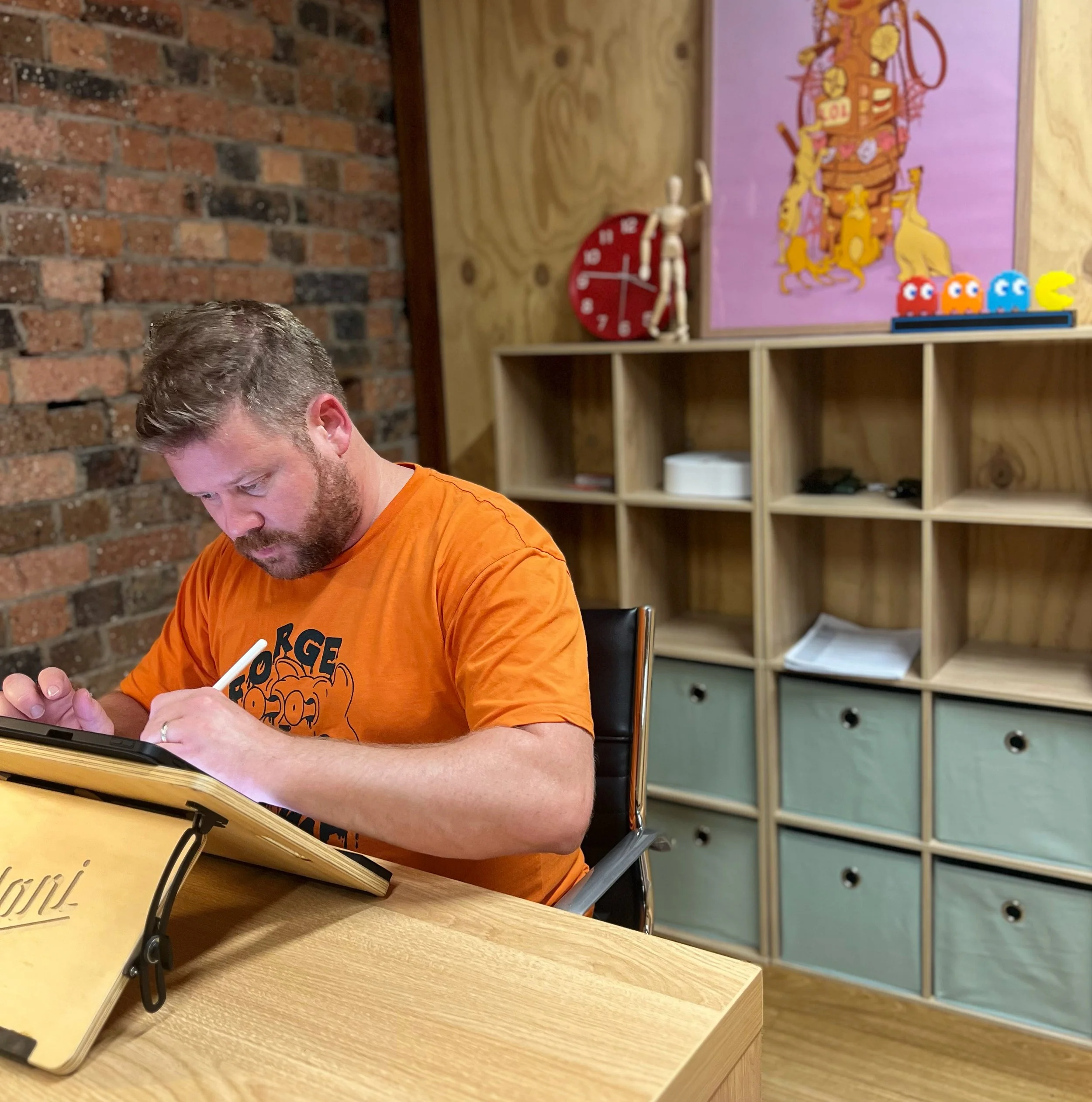 Jimmy Patch illustrating on an iPad in a colourful studio.