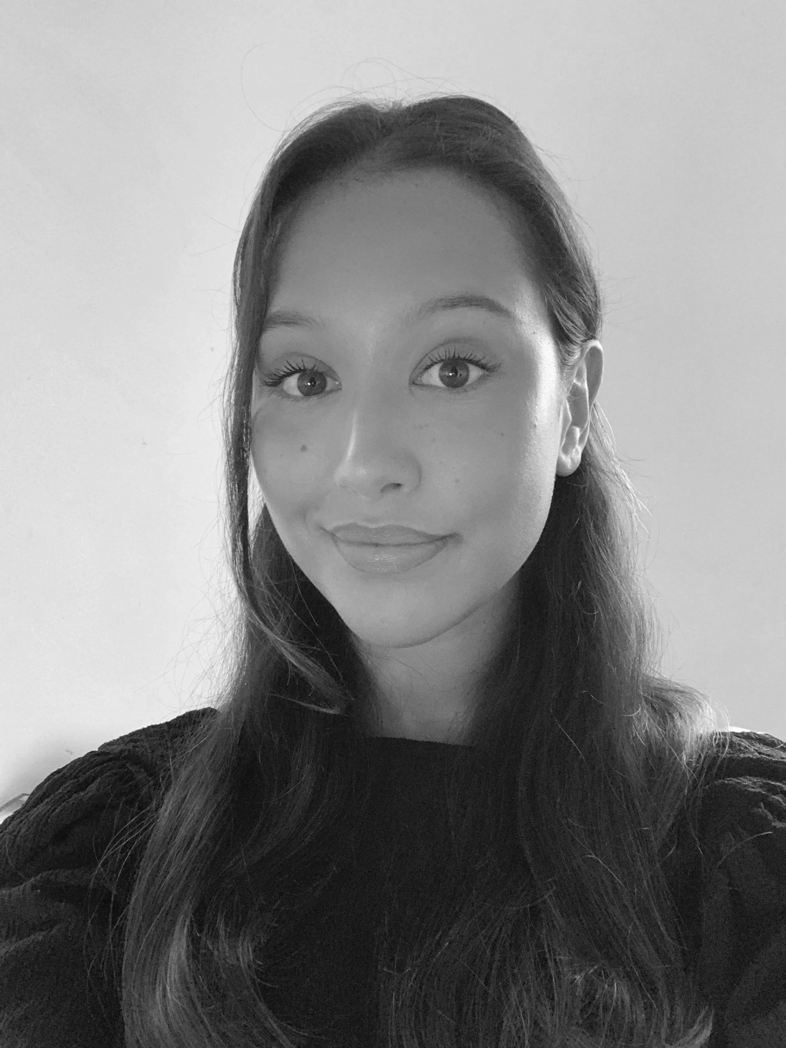 Black and white photo of a woman with long hair, smiling slightly, against a plain light background. Her name is Rebecca Wesström, intern at SACC San Diego for Business Development and Cleantech.