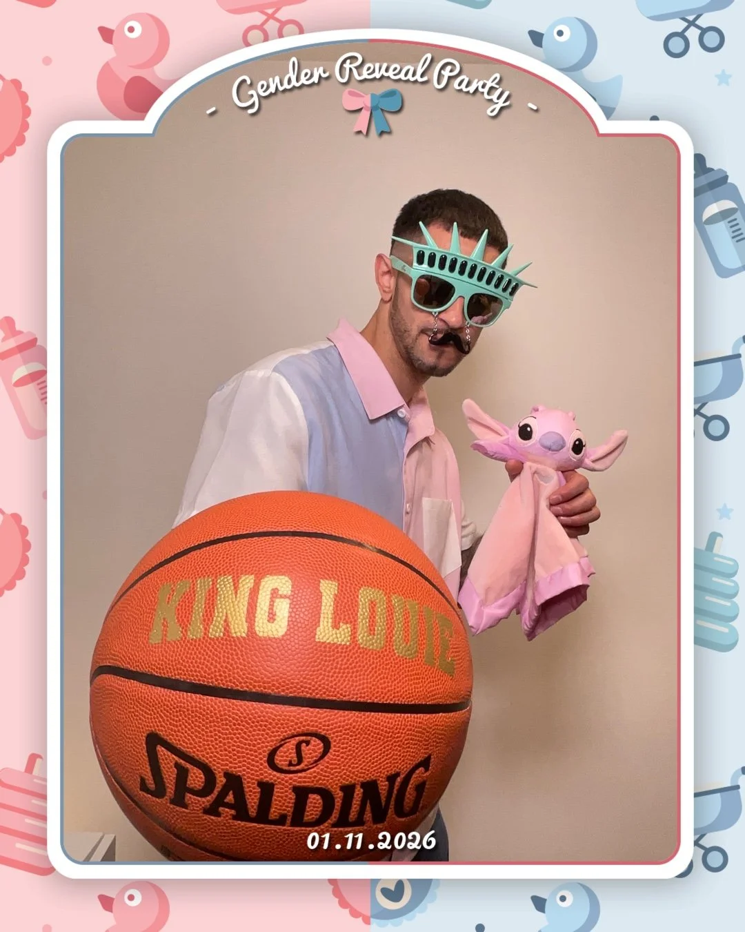 A person wearing novelty Statue of Liberty sunglasses, holding a pink plush toy of Baby Yoda, and standing behind a basketball with the words 'King Louis' and the date January 11, 2026, written on it. The background includes pastel-colored baby items