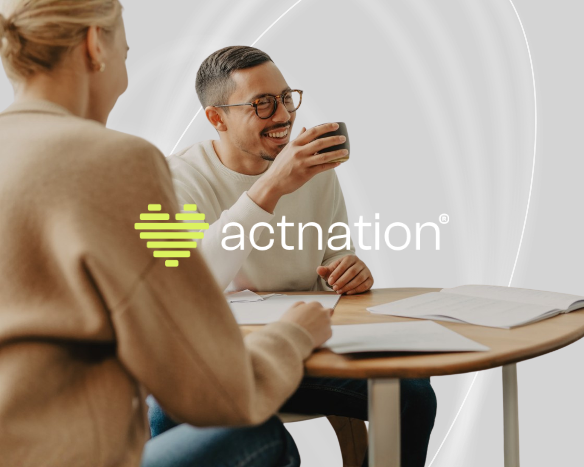 young man in work enviroment raising coffee cup with actnation logo