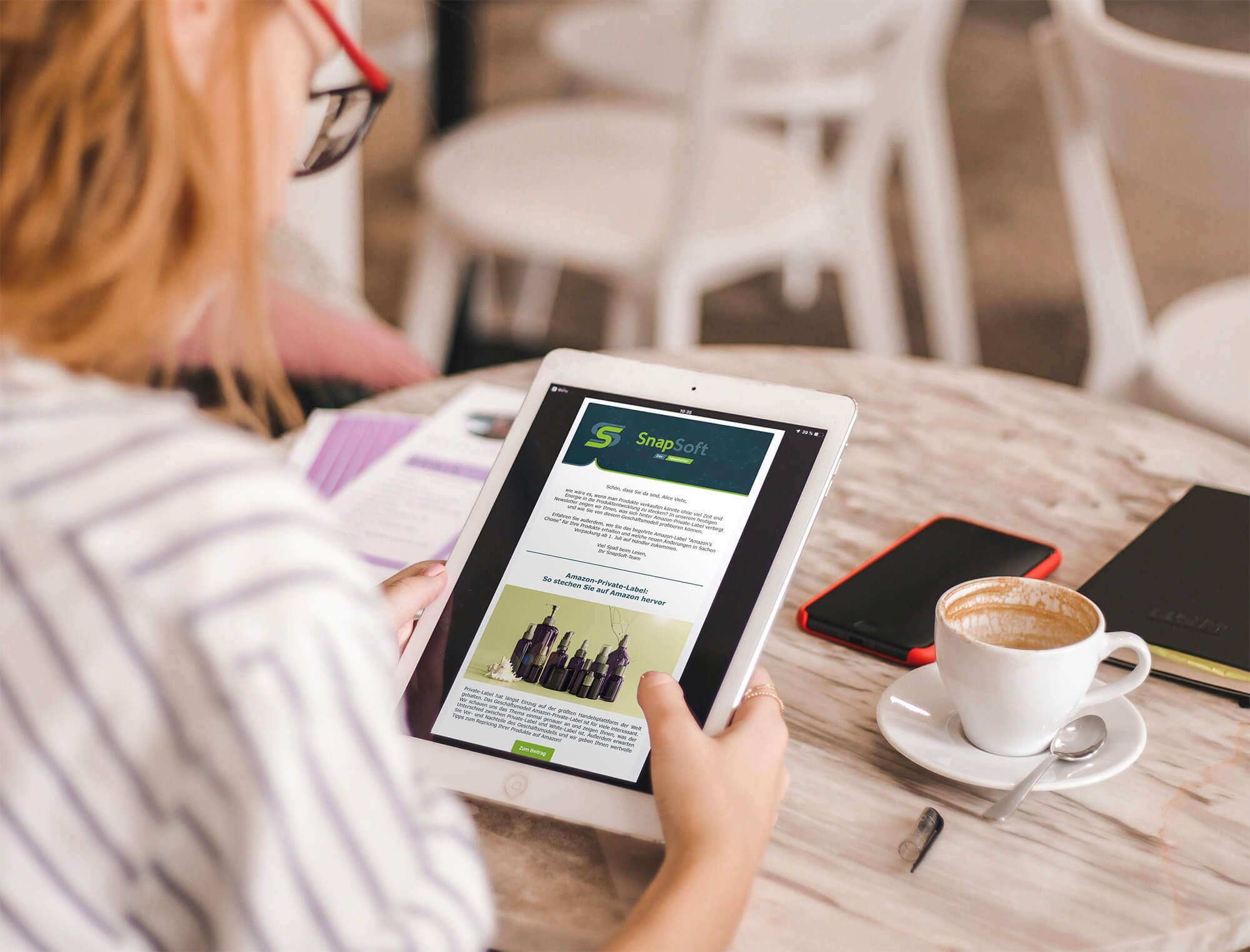 Frau hält Tablet in der Hand mit Snapsoft Newsletter