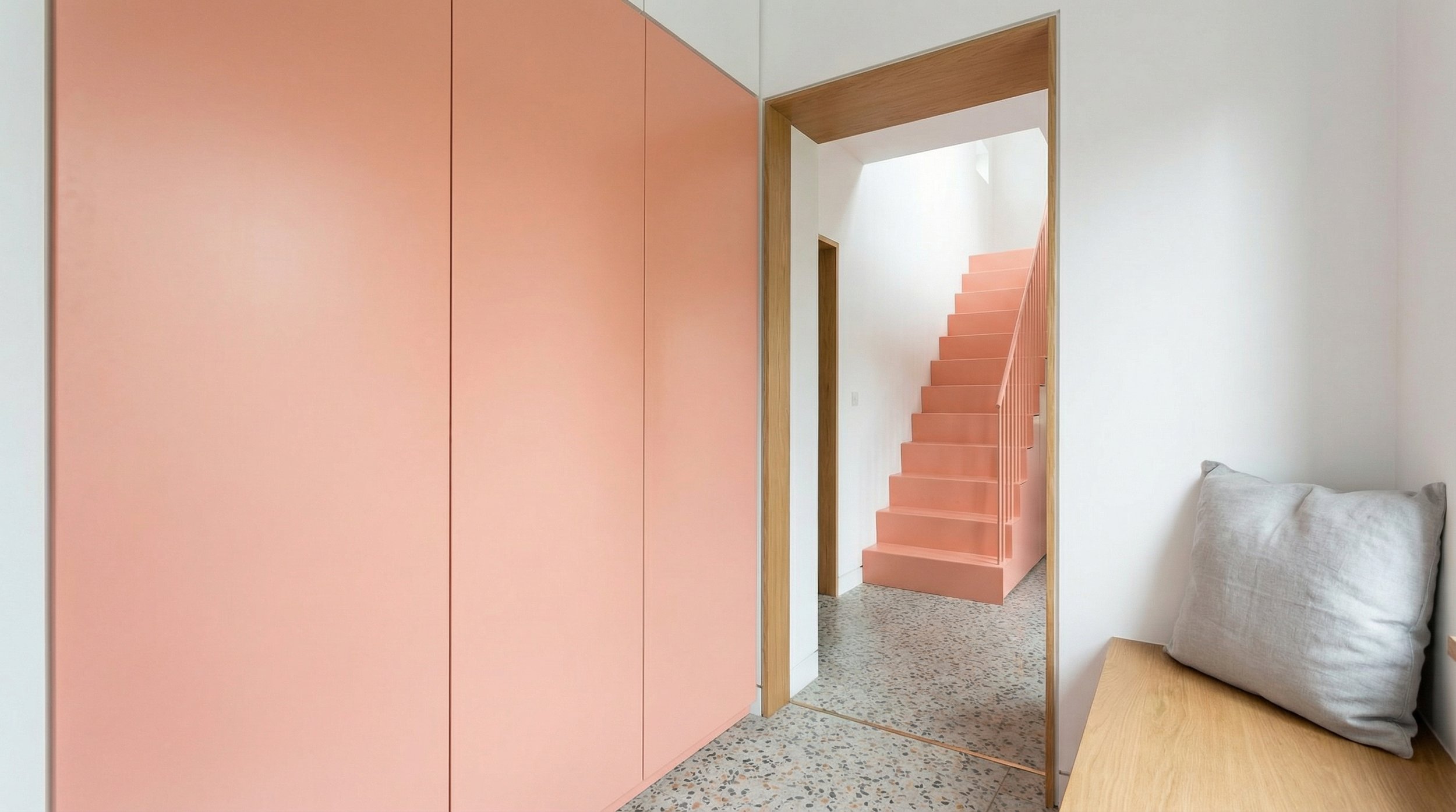 Built-in floor-to-ceiling pink cabinetry in entrance porch with oak door surround and terrazzo floor, house renovation Huddersfield.