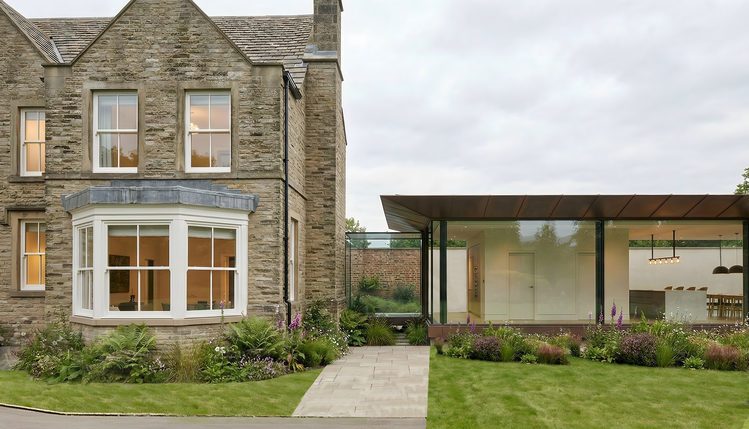 Close-up of glazed house extension with copper-clad flat roof connecting Victorian stone house to modern open-plan living space.