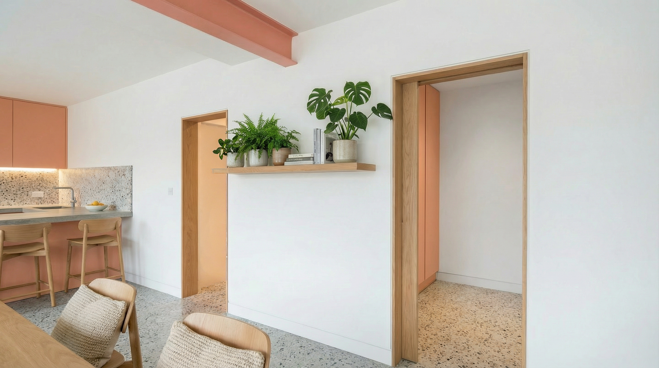 Kitchen diner with pink and sage green cabinetry, terrazzo splashback and island with oak bar stools, house renovation.