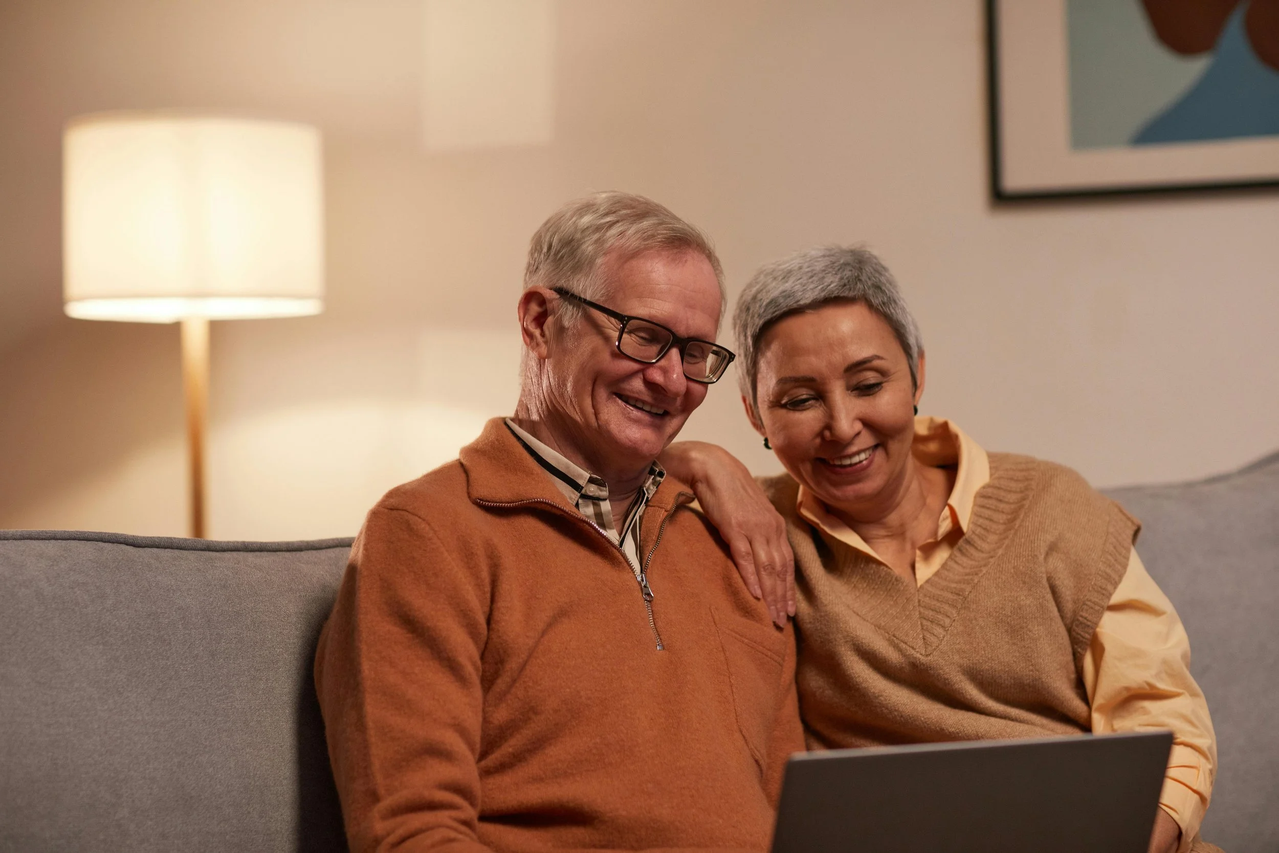Senior couple in their home in Sun Lakes using a laptop together, representing friendly in-home tech help for older adults.