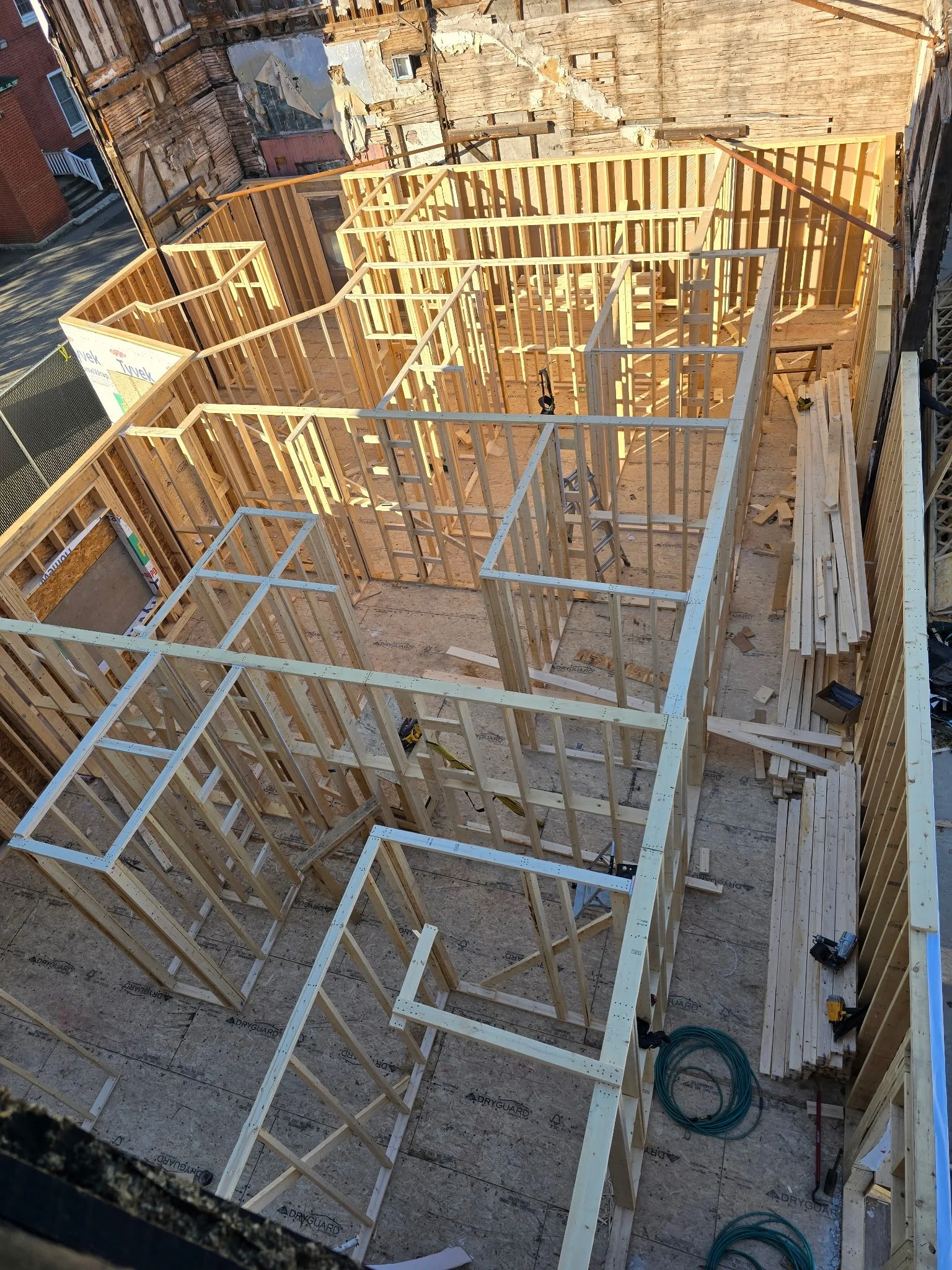View of a house under construction with wooden framing for walls and rooms.