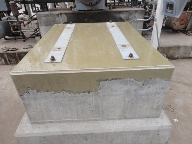 Epoxy grouted equipment foundation block with anchor bolt brackets in industrial facility