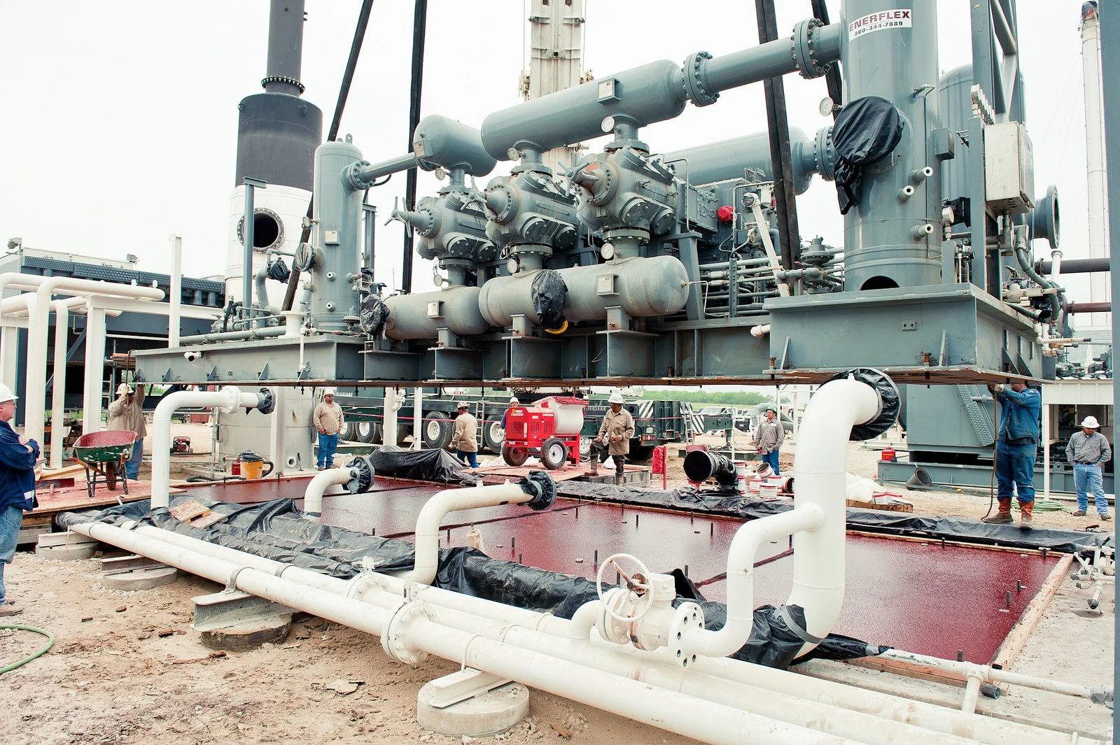 Workers installing large industrial machinery on epoxy grouted foundation