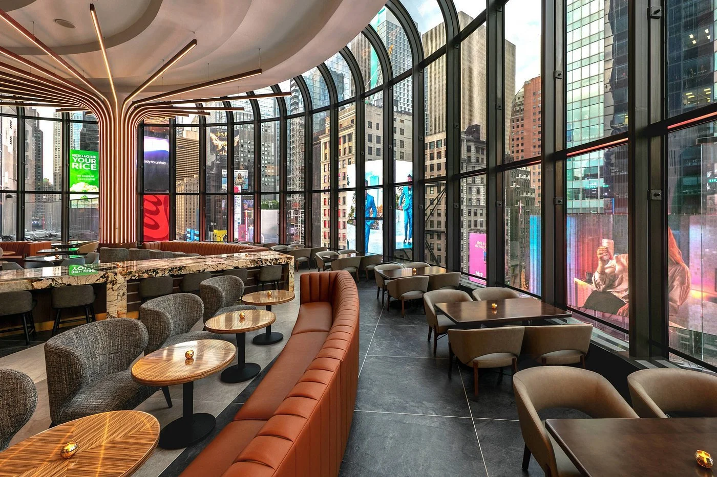 Hotel lounge with curved floor-to-ceiling windows over Times Square