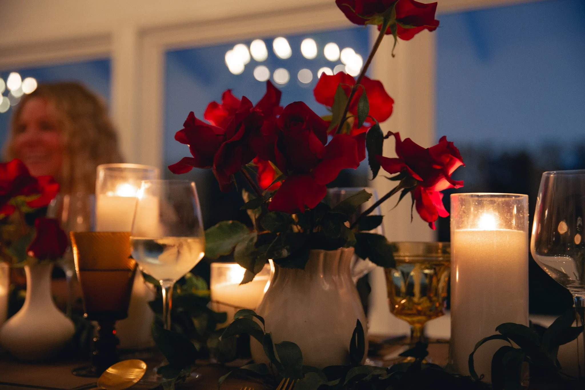A woman with short hair looking at a tablet, with a pink filter overlay. Text on the image reads "Our Work" in large block letters and "Designed by" in red cursive, with a small bird illustration.