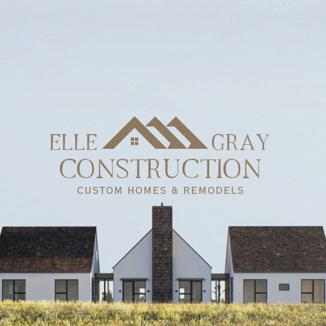 Sign for Elle Gray Construction, featuring a logo of three house rooftops with a small window, and a row of modern homes in the background.