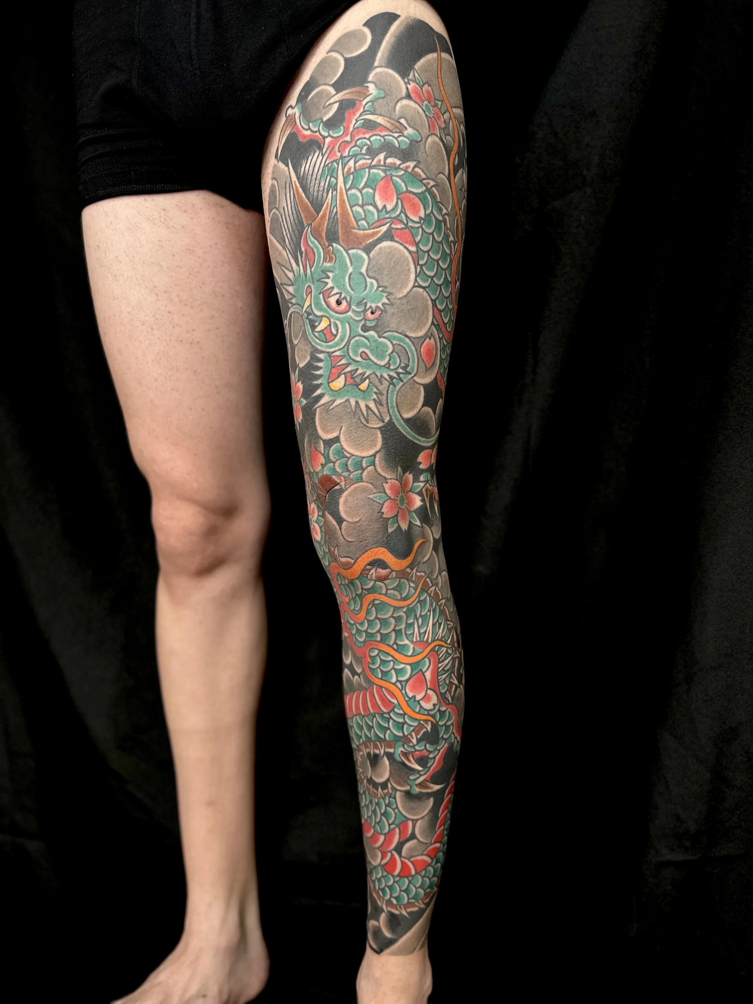 Tattoo tradicional japonés de pierna completa con dragón y flores Sakura hecho en Castellón , Valencia y Madrid