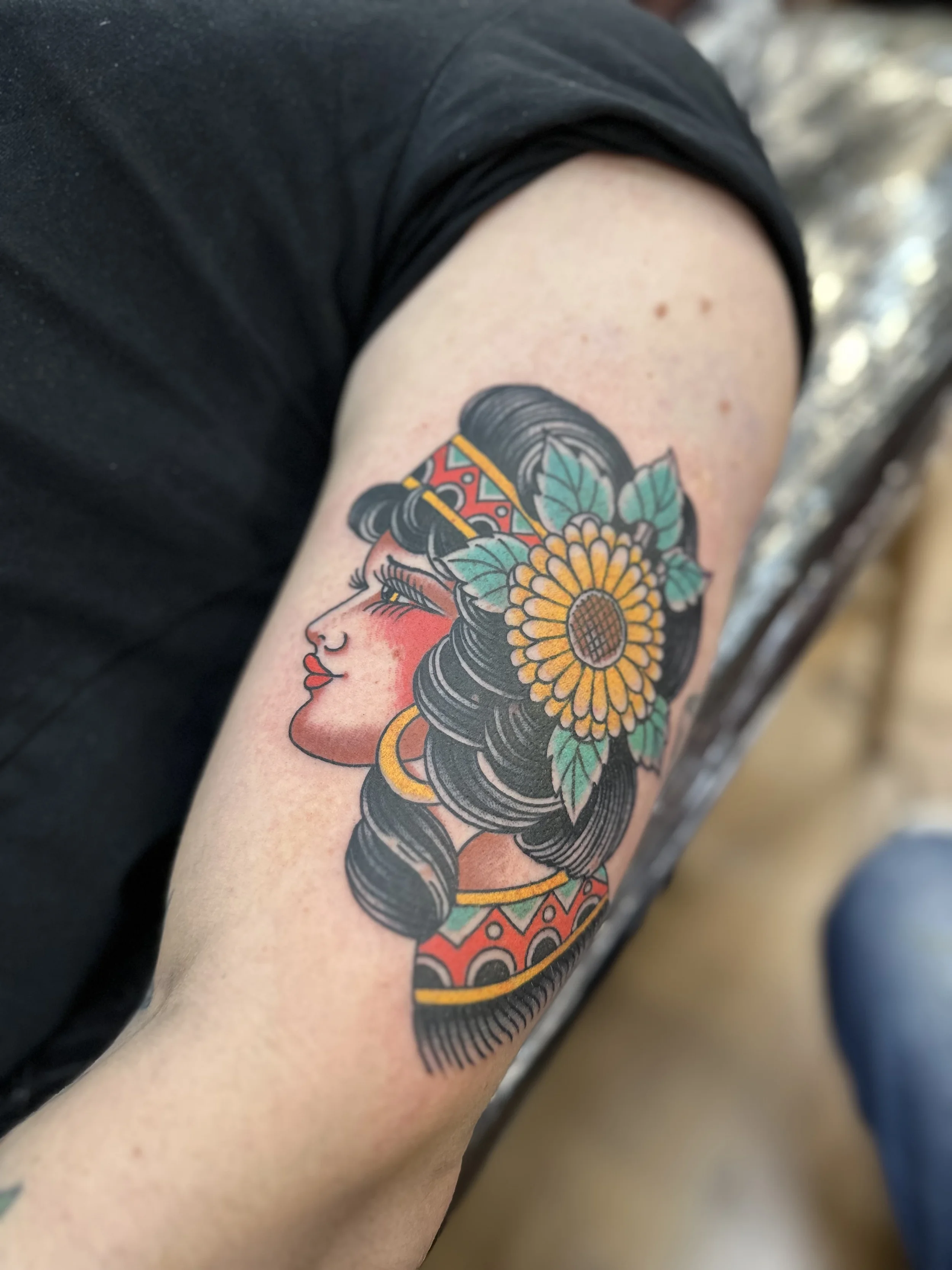 Tattoo tradicional de cara de chica y girasol hecho en True Love tattoo madrid en Malasaña 