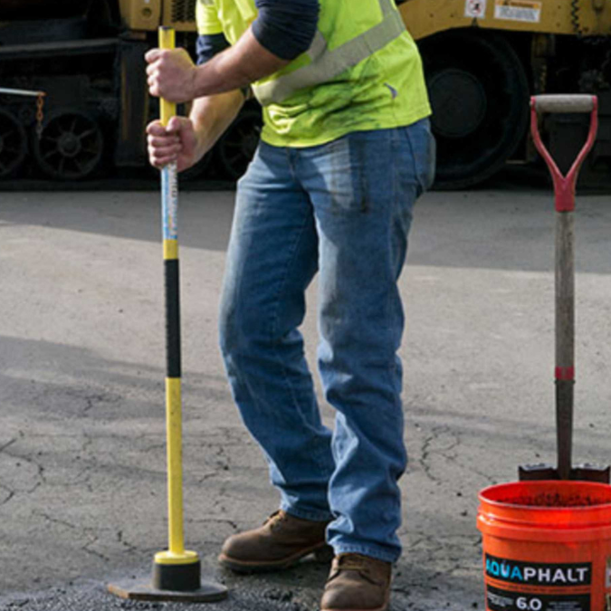 image of man using Glenco Supply Aquaphalt to repair the road