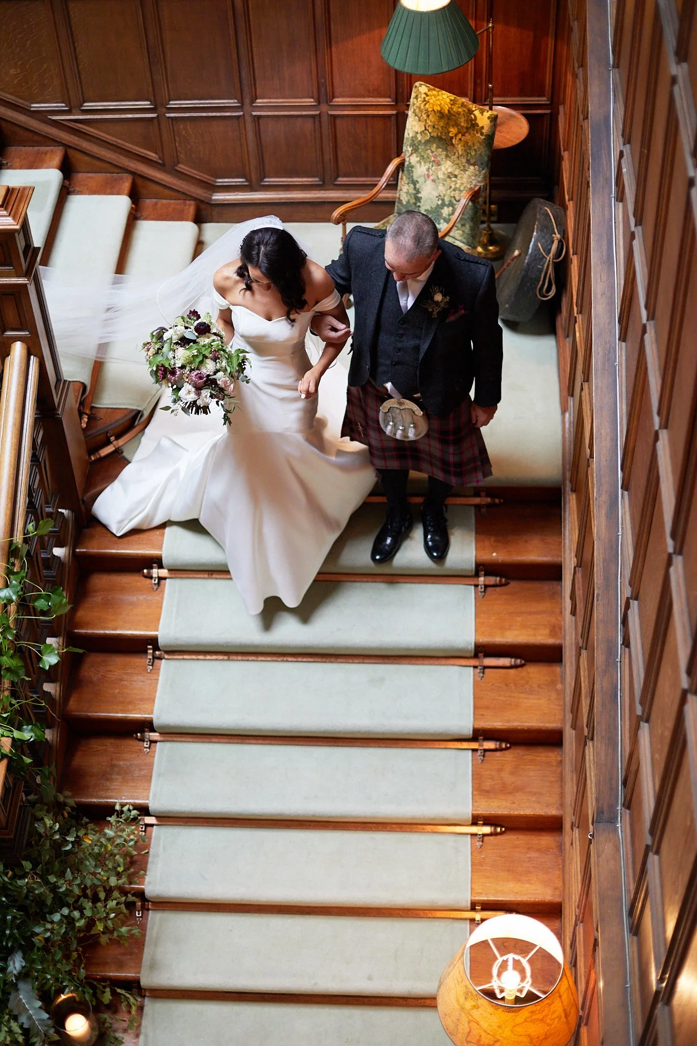 Bride and groom walking down elegant staircase
