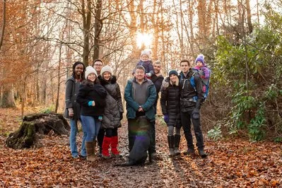 Group of people posing in a forest with autumn leaves