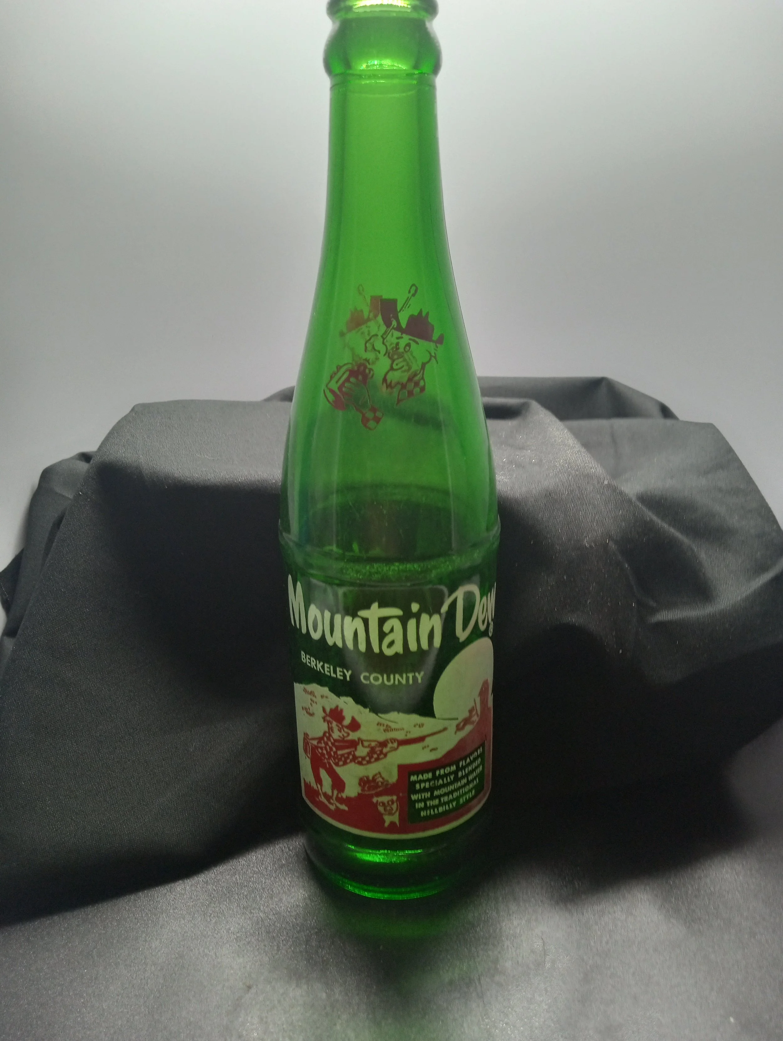 AGE - 1964
TYPE - MACHINE
FRONT - MOUNTAIN DEW
BERKELY COUNTY
MADE FROM FLAVORS
SPECIALLY BLENDED
WITH MOUNTAIN WATER
IN THE TRADITIONAL
HILLBILLY STYLE
BACK - MOUNTAIN DEW
IS GOOD!
BOTTOM - L64
29 940
12 FL OZS
RARITY - COMMON