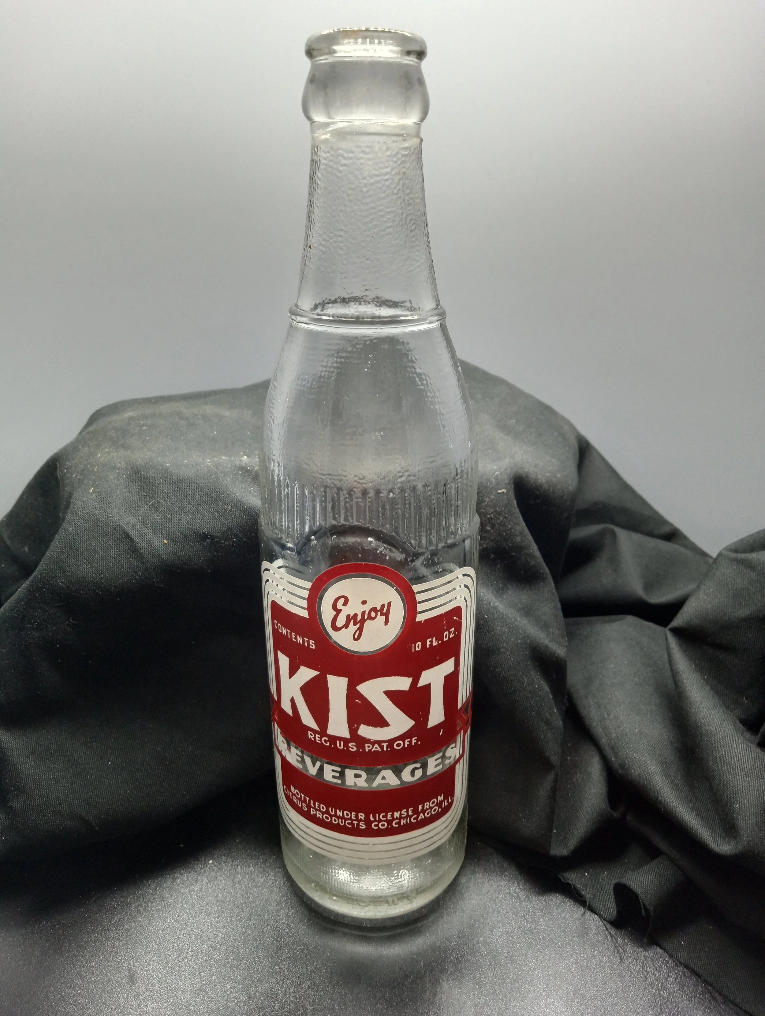 AGE - 1949 - TYPE - MACHINE - FRONT - ENJOY / CONTENTS 10 FL. OZ. / KIST / REG. U.S. PAT. OFF. / BEVERAGES / BOTTLED UNDER LICENSE FROM / CITRUS PRODUCTS CO. CHICAGO, ILL. (embossed at base) 4 L G W 9 - BACK - GREER BOTTLING CO. / GREER,S.C. - COLOR