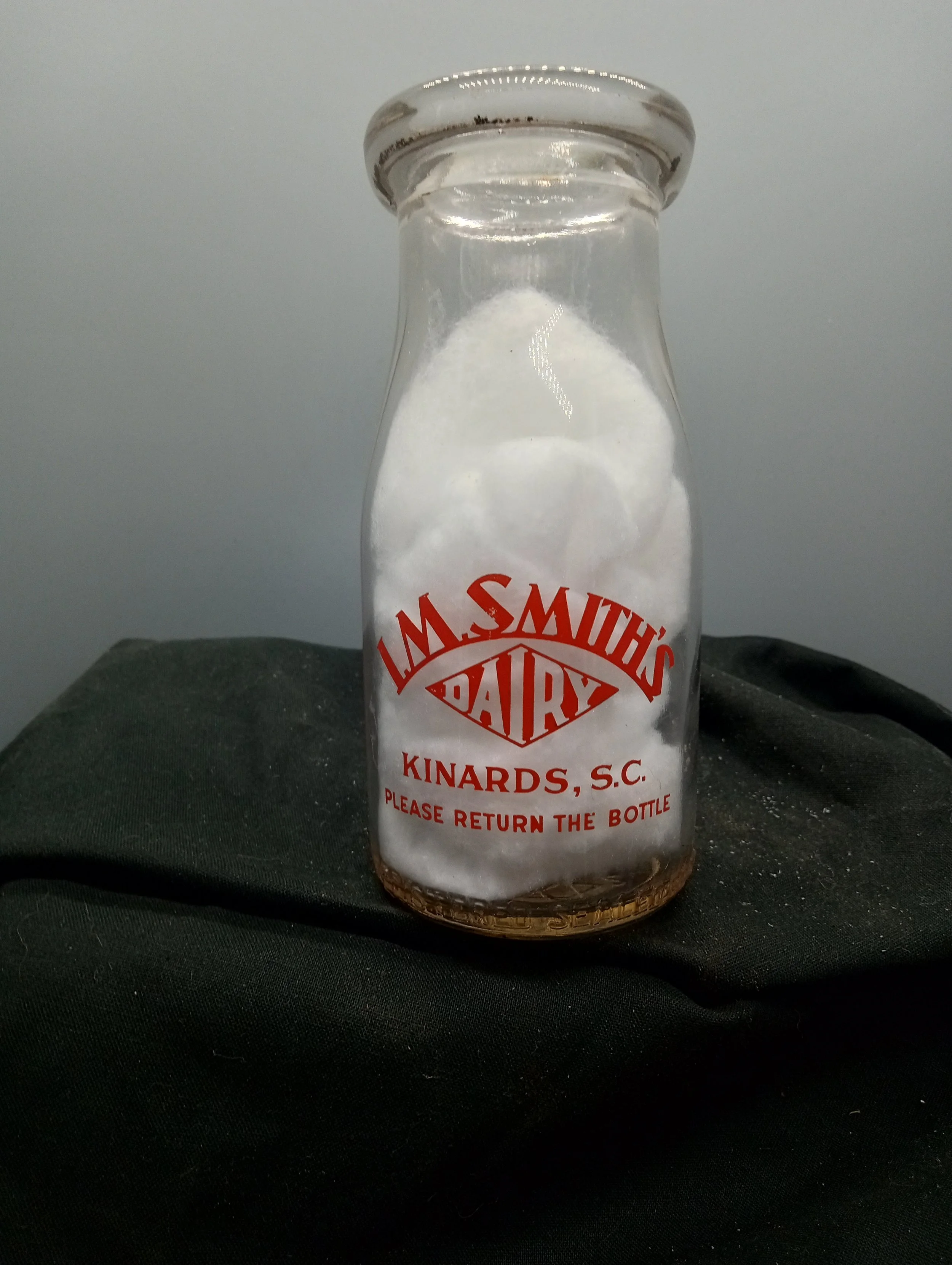 AGE - 1948 - FRONT - L.M. SMITH'S / DAIRY / KINARDS, S.C. / PLEASE RETURN THE BOTTLE (embossed at base) REGISTERED SEALED BB 48 - BACK - THE MORE MILK . THEMORE / HEALTH AND HAPPINESS. (embossed at base) HALF PINT LIQUID