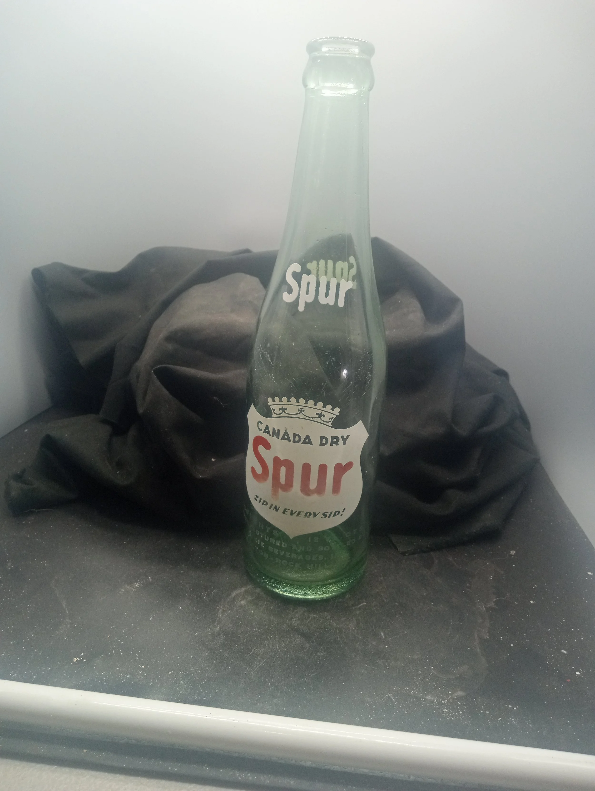 AGE - 1949 - TYPE - MACHINE - FRONT - (shoulder) SPUR (body) CANADA DRY / SPUR / ZIP IN EVERY SIP! / CONTENTS 12 FL. OZS. / MANUFACTURED AND BOTTLED BY / DIXIE BEVERAGES, INC. / CLINTON - ROCK HILL, S.C. (embossed at base) 4LGW9 - COLOR - AQUA \ RARI