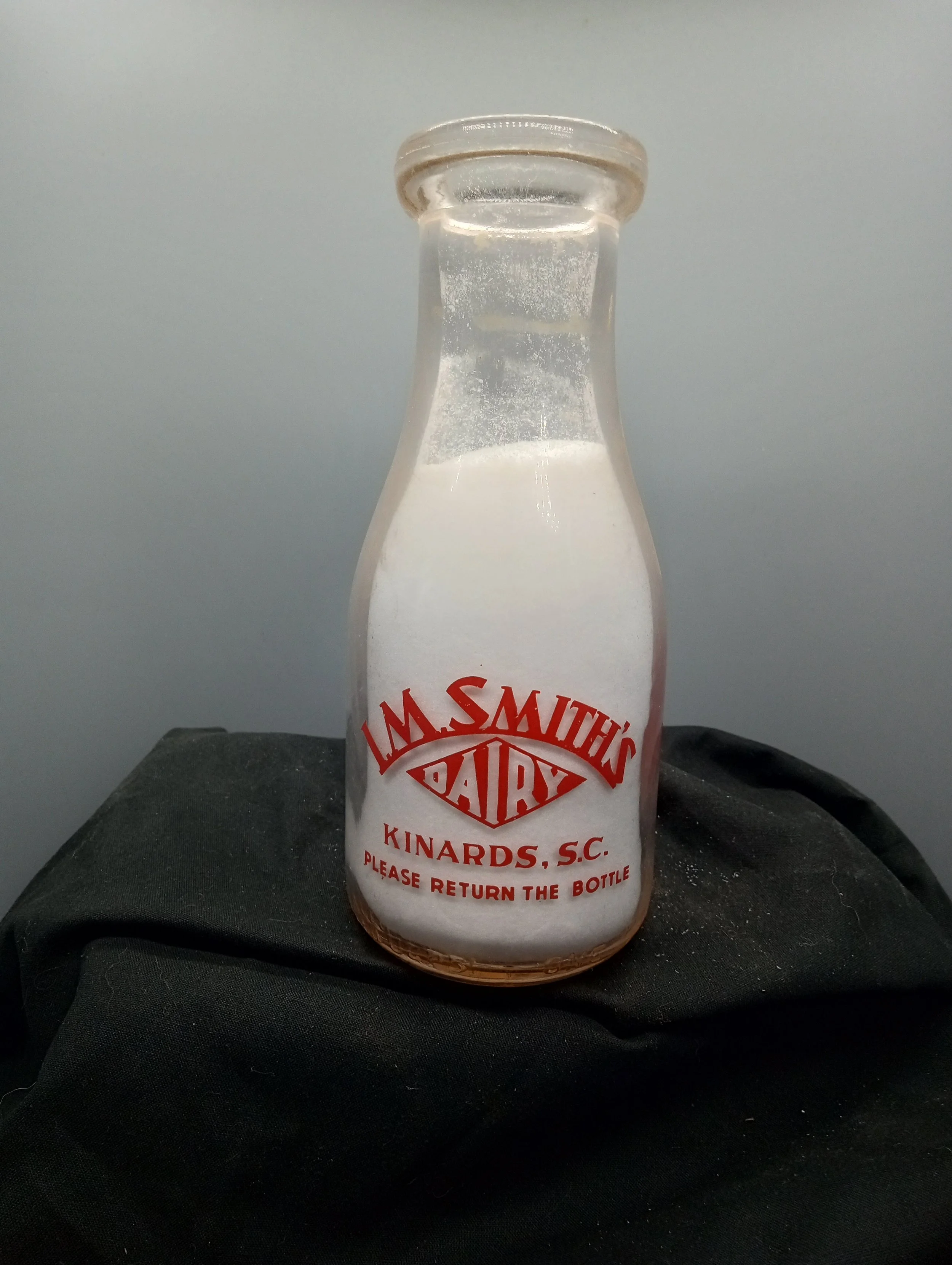 AGE - 1951 - FRONT - LM SMITH'S / DAIRY / KINARDS, SC / PLEASE RETURN THE BOTTLE (embossed at base) REGISTERED SEALED ULP 51 - BACK - DRINK / MORE / MILK / THE HEALTH PARADE (embossed at base) ONE PINT LIQUID