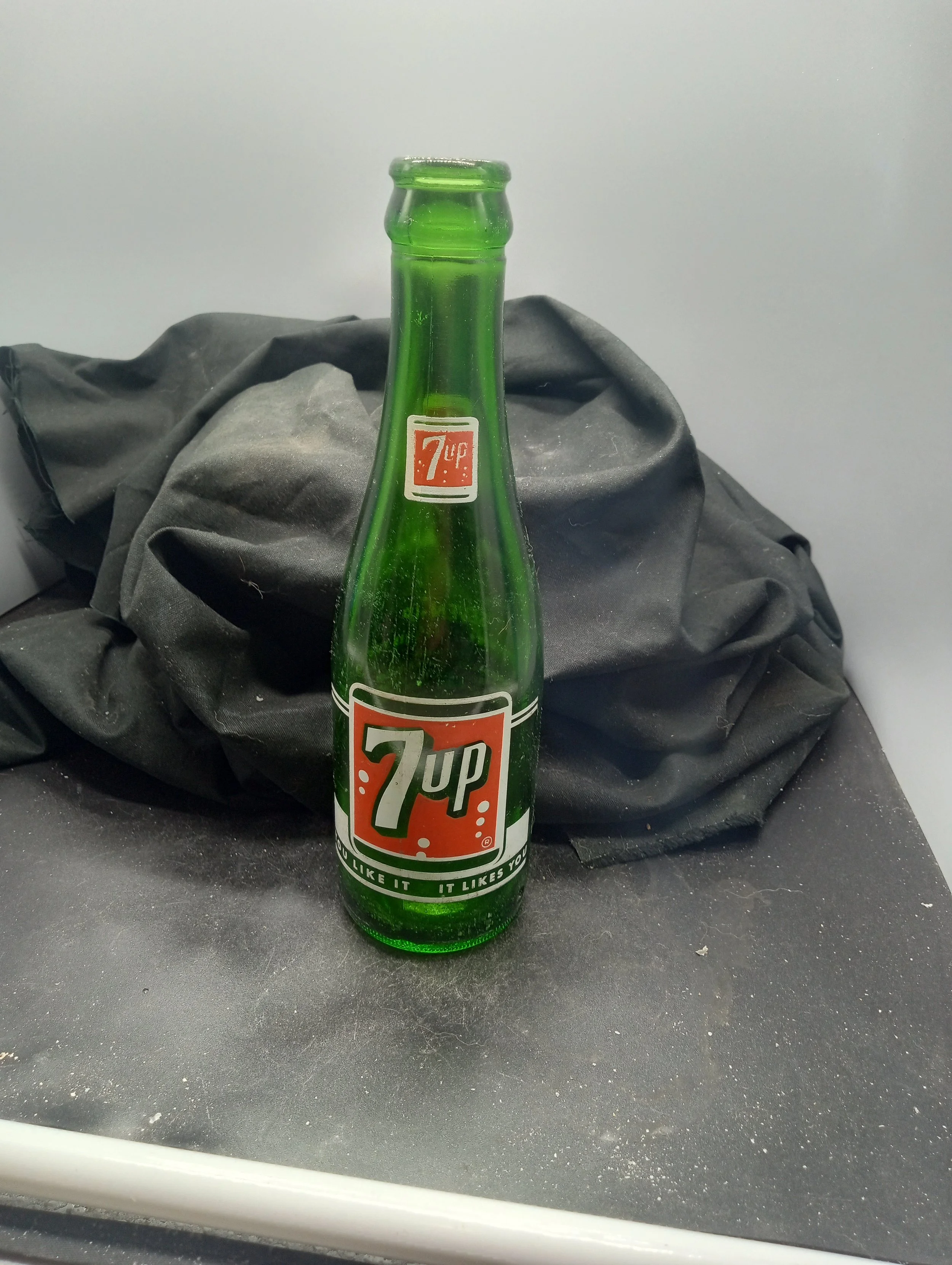 AGE- 1964 - TYPE - MACHINE - FRONT - (shoulder) 7up (body) 7up (R) / YOU LIKE IT  IT LIKES YOU  - BACK - CONTENTS 7 FL. OZS. / ESVEN-UP FLORENCE BOTTLING CO. / FLORENCE, S.C. - BOTTOM - G-94  3(I)65  20 - COLOR - GREEN \ RARITY - SCARCE