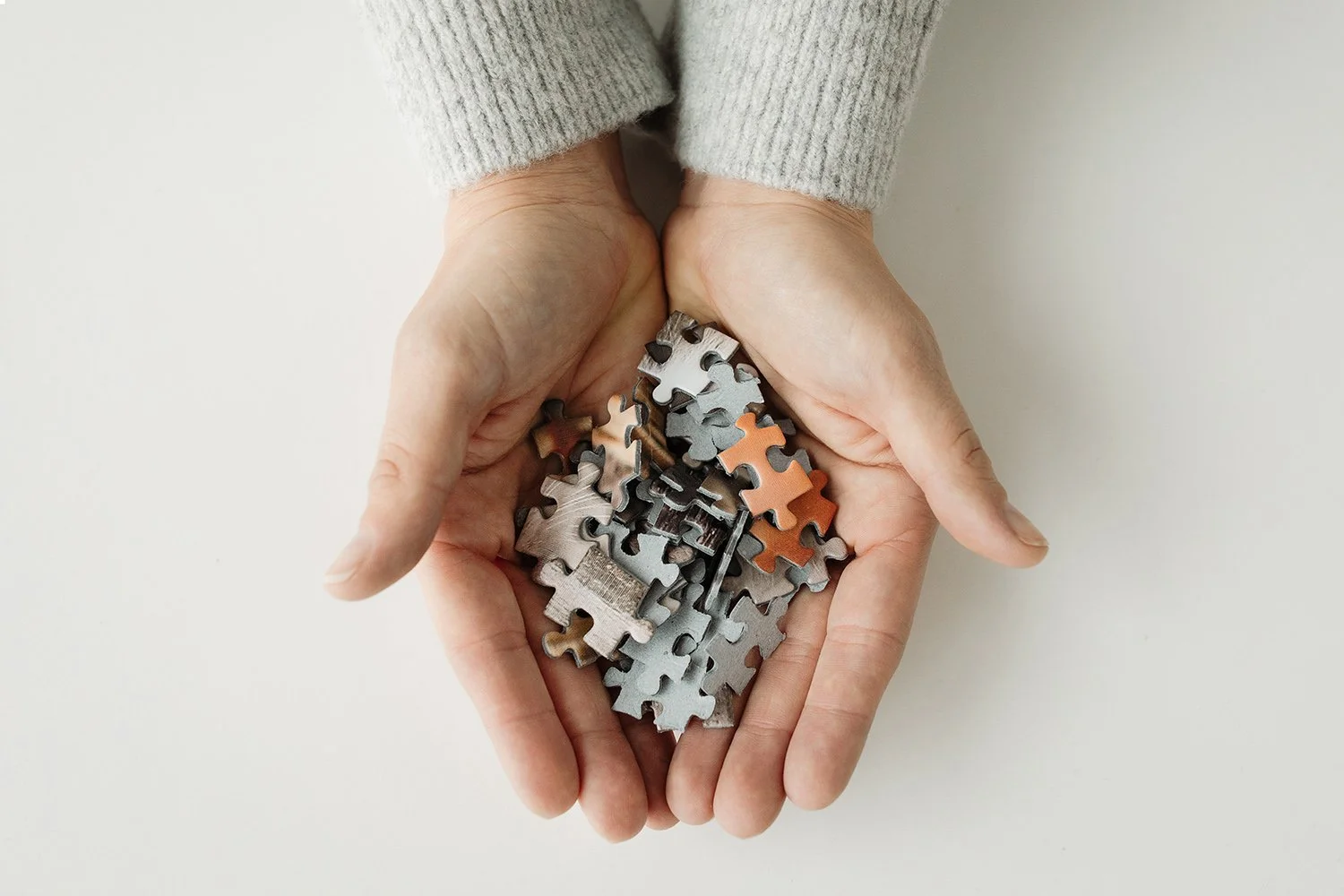 Two hands holding puzzle pieces.