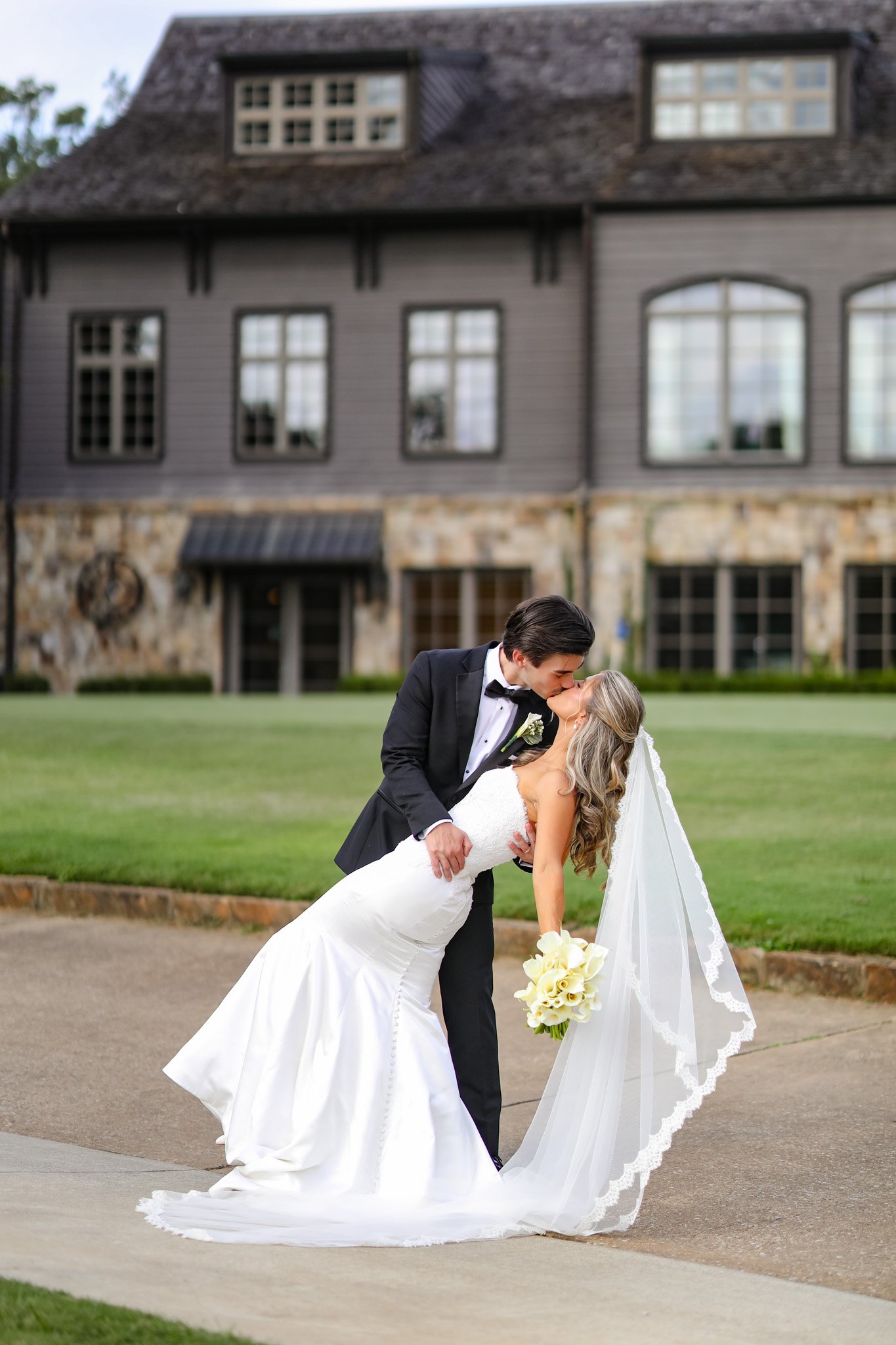 Bride and groom kissing during engagement-style wedding portraits