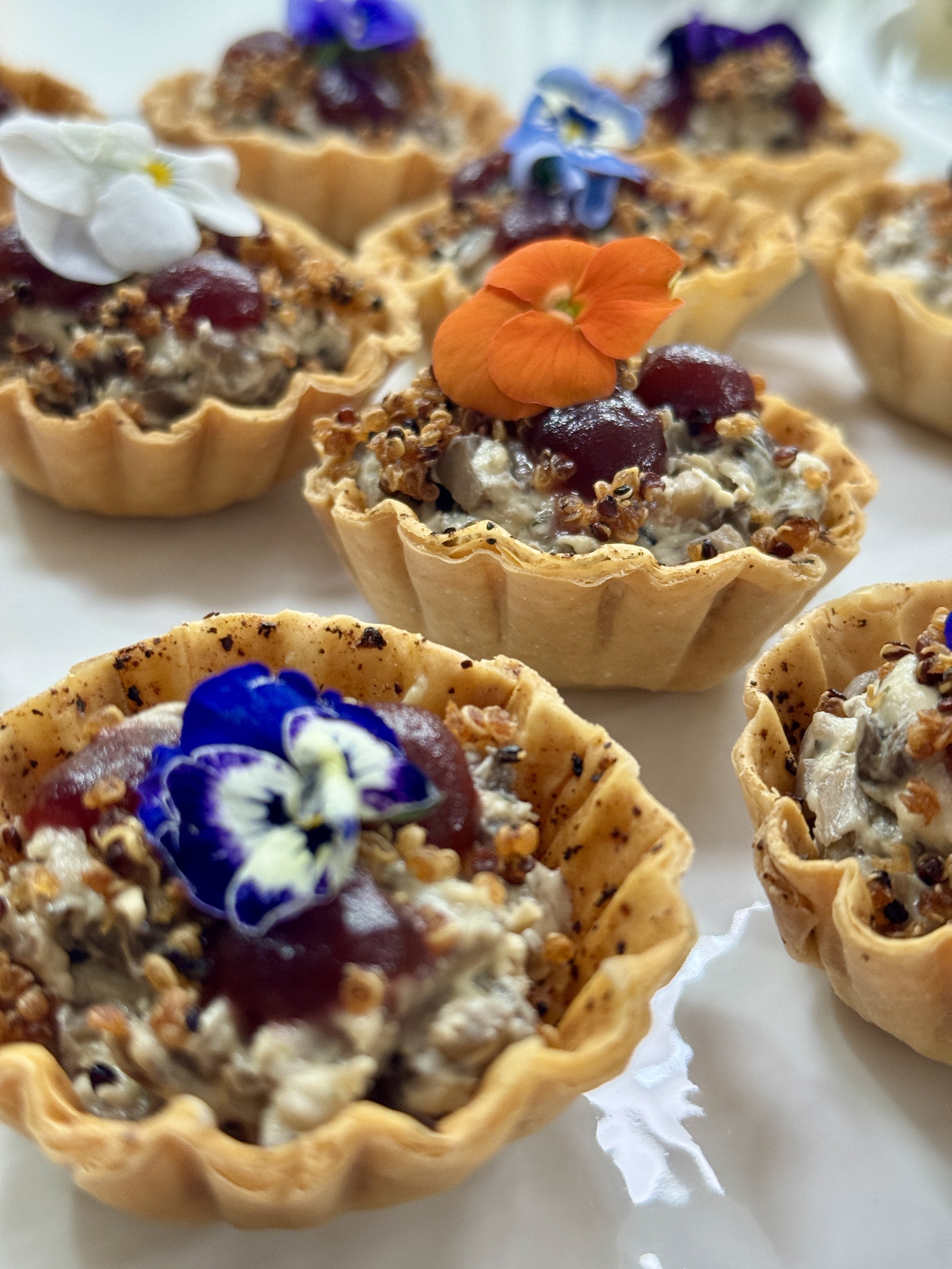 Savory mushroom tartlets garnished with edible flowers