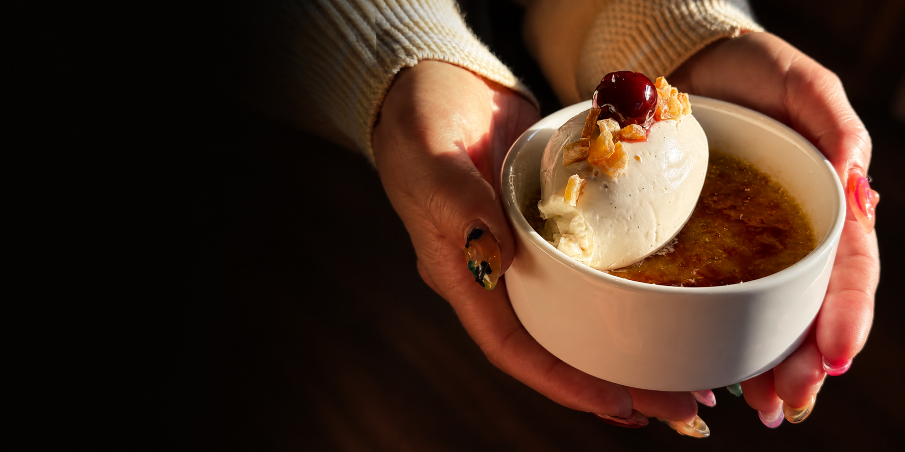 Guest holding a crème brûlée dessert during a Gourmet All Day private dining experience