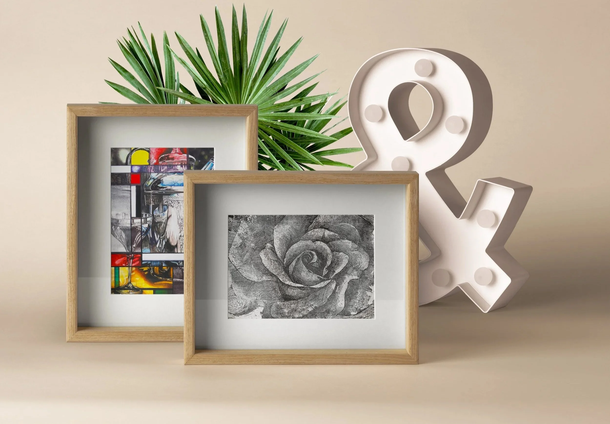Arrangement of framed artwork and decor objects including a large green plant, a stylized white question mark with circular accents, and various pieces of artwork on a neutral background.