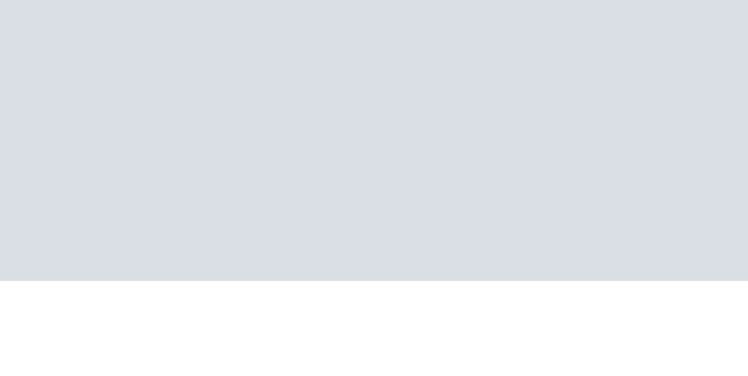 The image shows a computer monitor with a light blue screen, a keyboard, and a mouse on a white desk.