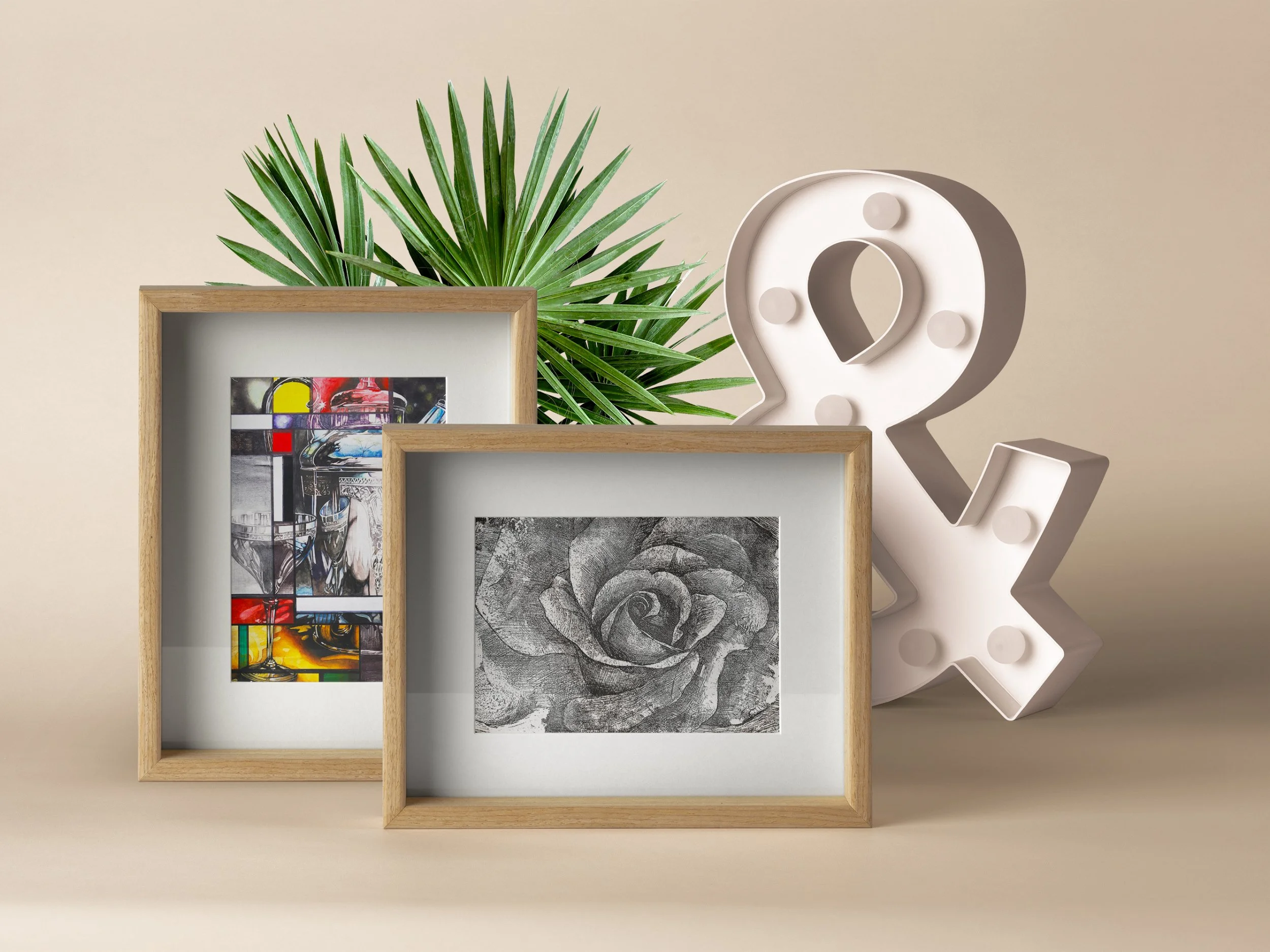 Decorative wall with framed artwork, a large green plant, and a white sculpture with round accents.