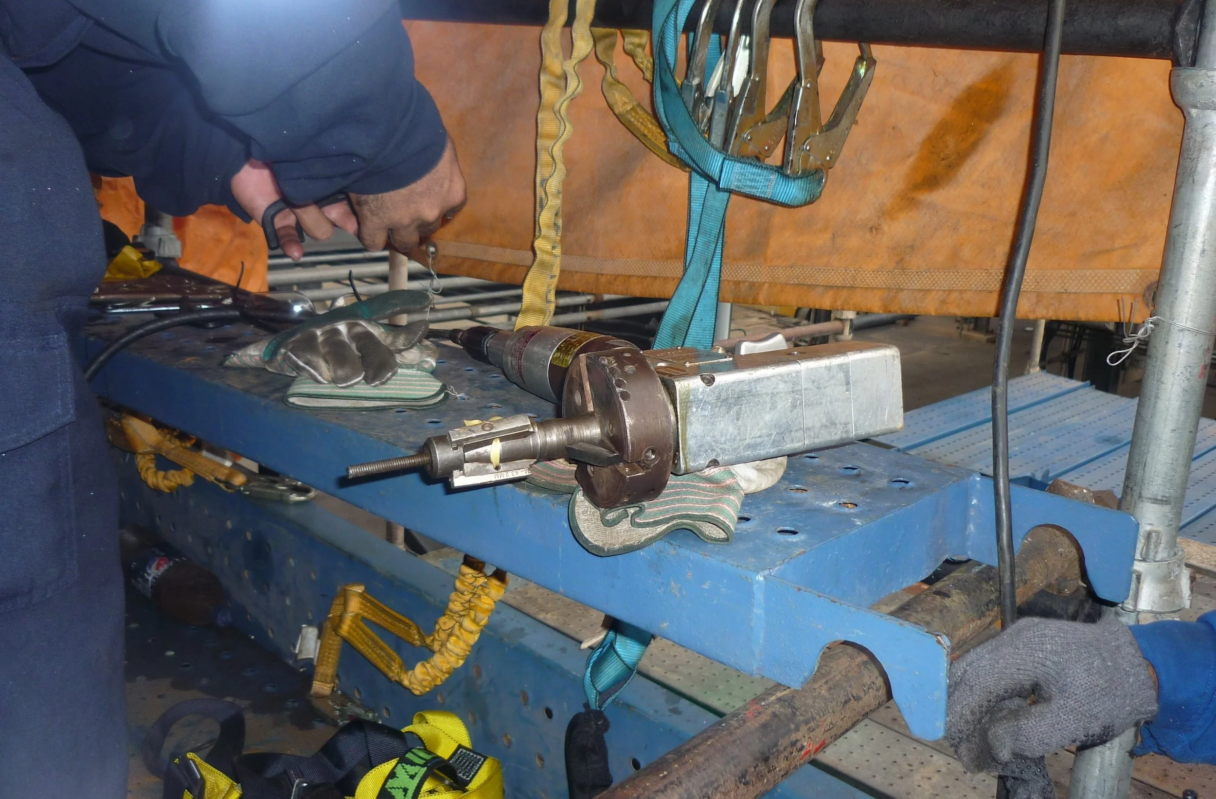Persona trabajando en un taller de reentubado de intercambiadores de calor.