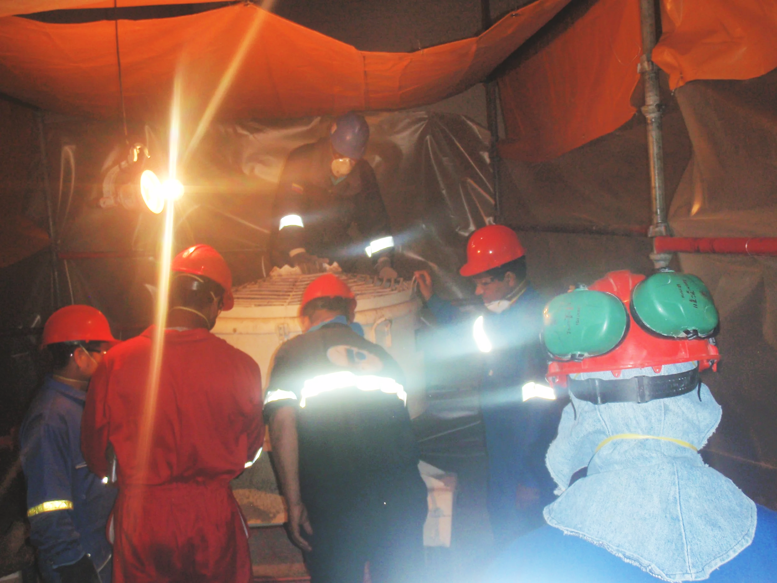 Personal en la mezcladora en  sitio de construcción observando una estructura con equipo de protección.