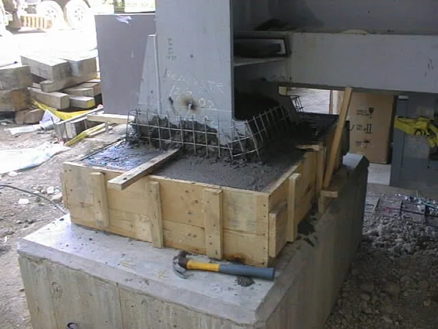 enconfrado  de madera con un marco de metal y malla de alambre, en construcción o reparación, en un área de trabajo con sombra.