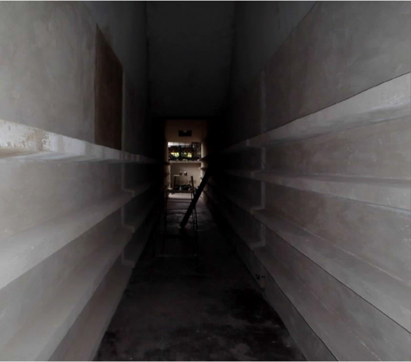 Dos trabajadores en equipo usando casco, gafas y máscara de protección, trabajando en una Estructura de acero con anclajes refractarios en un sitio de construcción.
