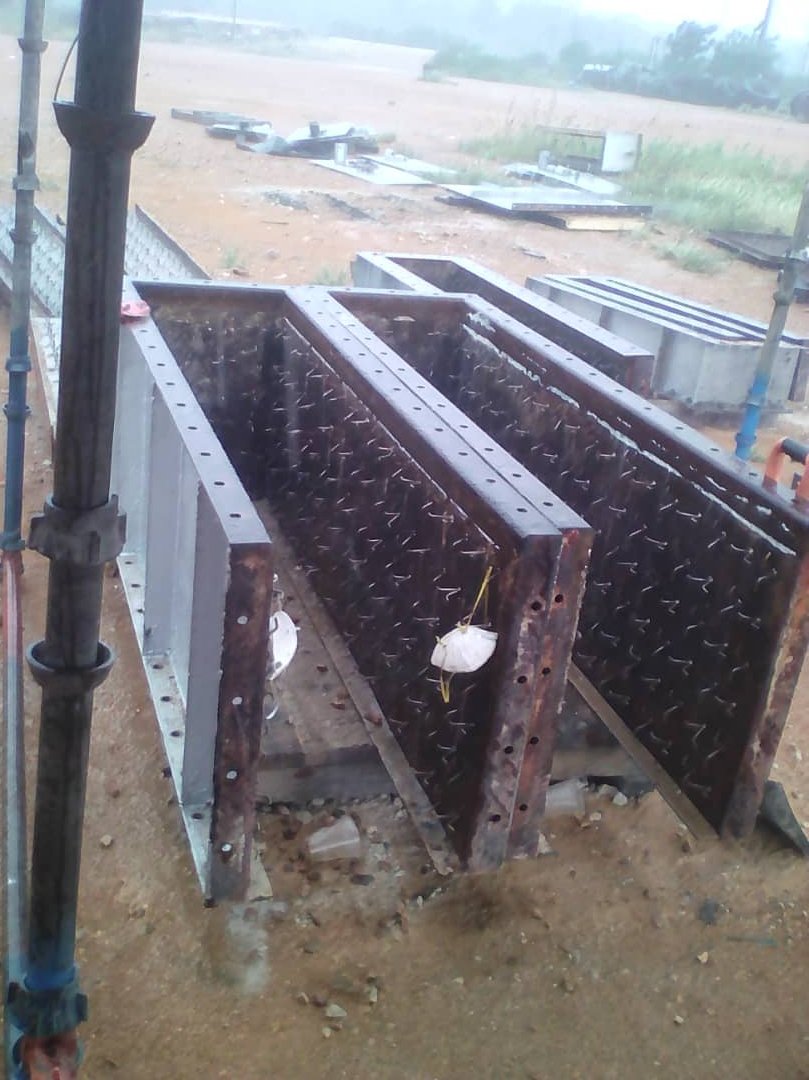 Estructura metálica en construcción en un sitio de obra, con varias partes ensambladas y pilares de sostenamiento.