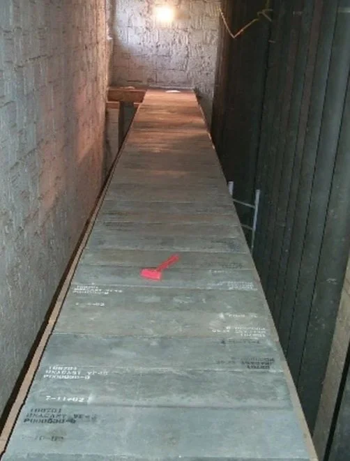 una mesa de madera en construcción en un espacio cerrado con paredes de ladrillo y madera