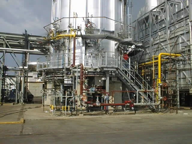 Infraestructura industrial con tuberías, tanques y maquinaria metálica.