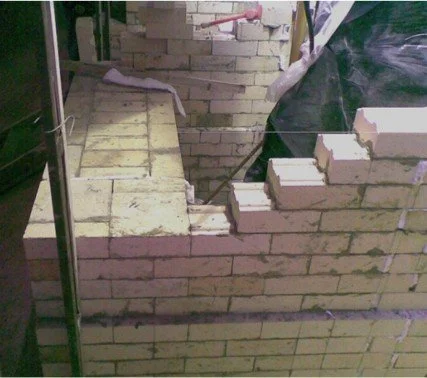 Muro de ladrillos refractario en construcción.