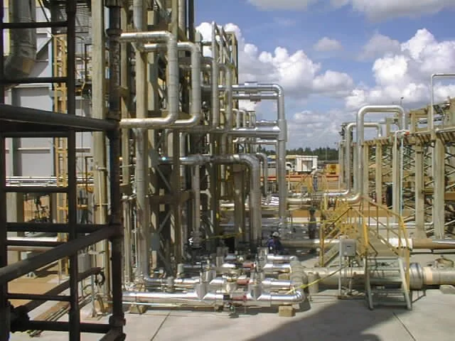 Planta industrial con tuberías de acero y estructuras metálicas.